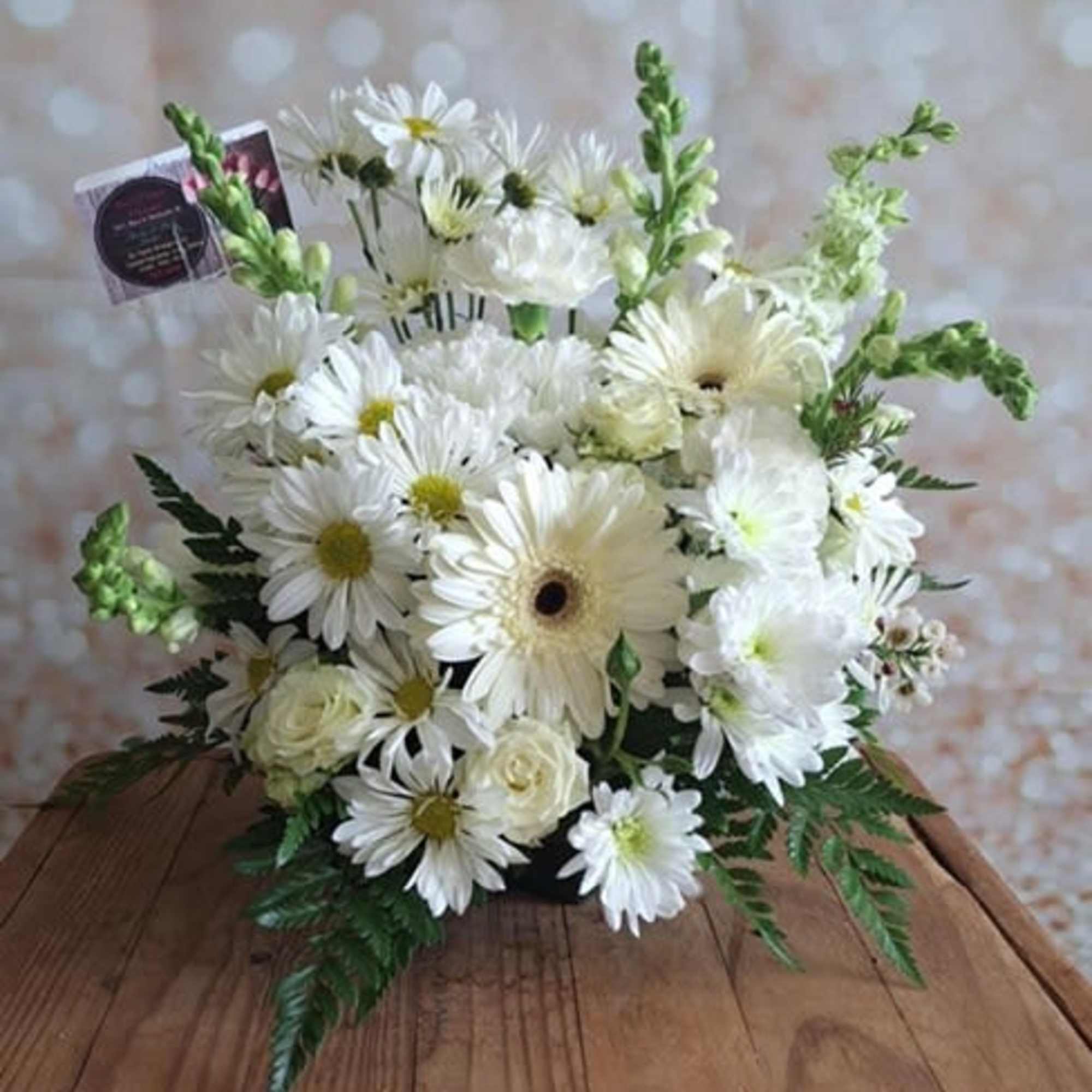 White daisy and rose bouquet in a low container