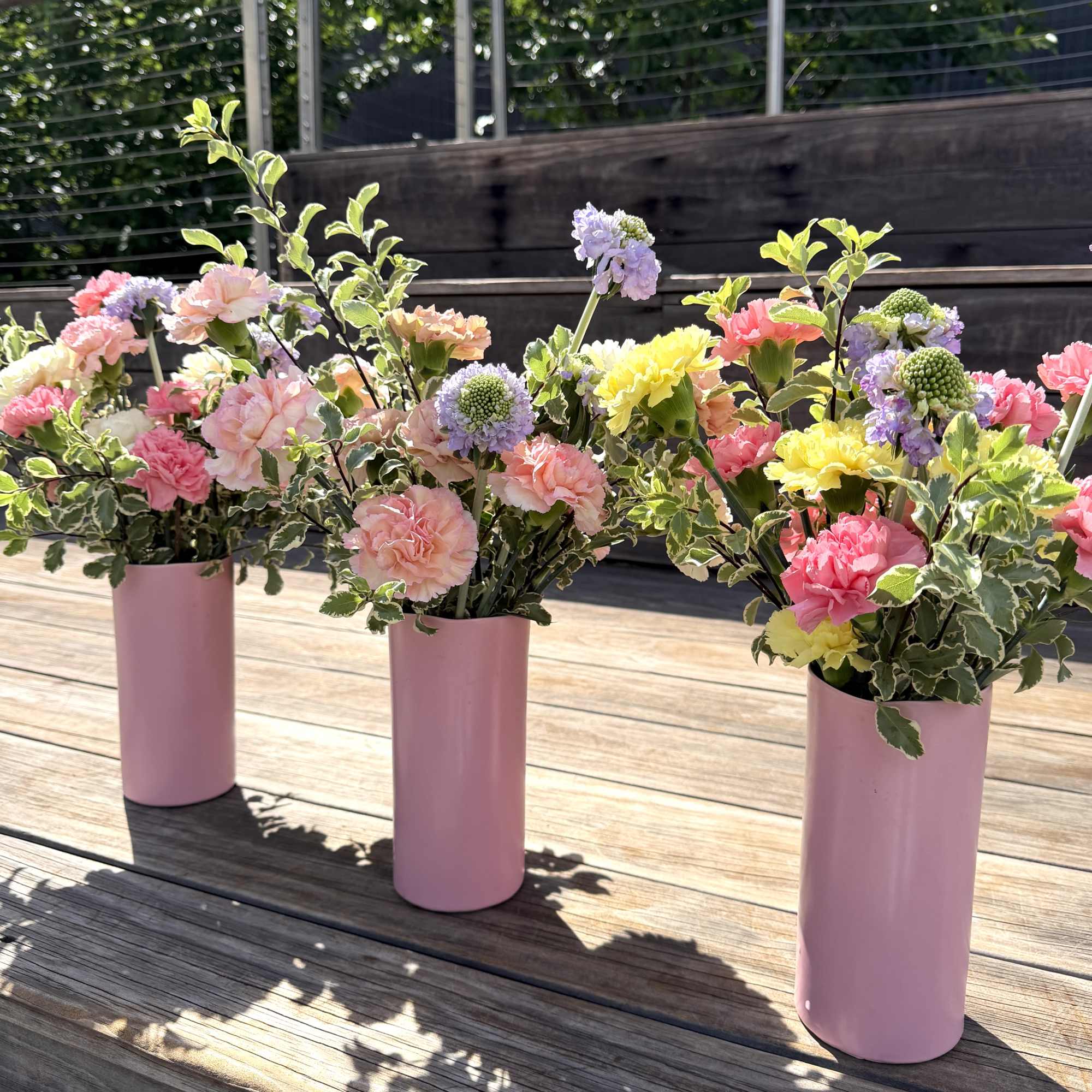 Soft, garden-fresh carnations in blush pink, peach, lavender, yellow and white bring