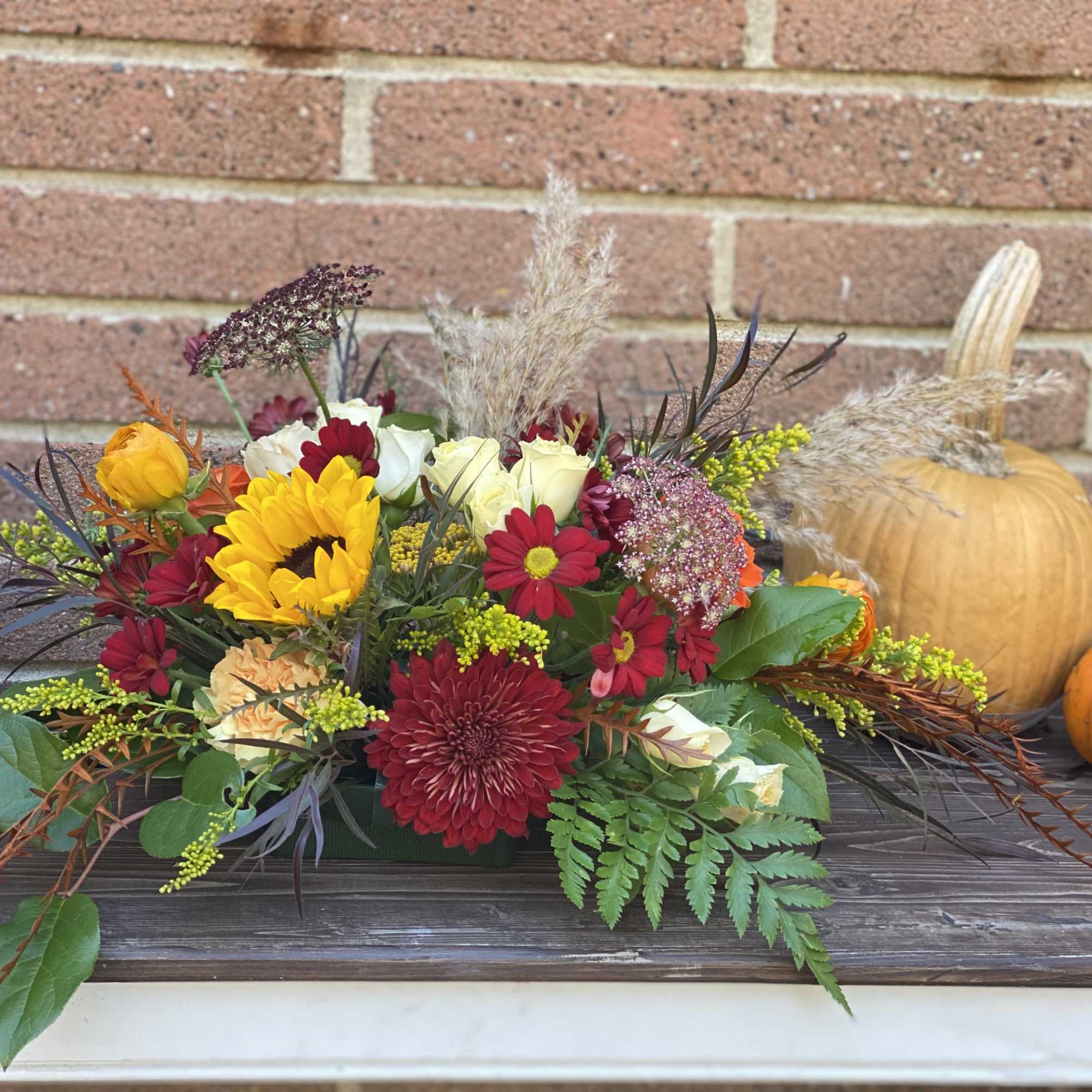 Autumn floral centerpiece with pumpkins on a table
