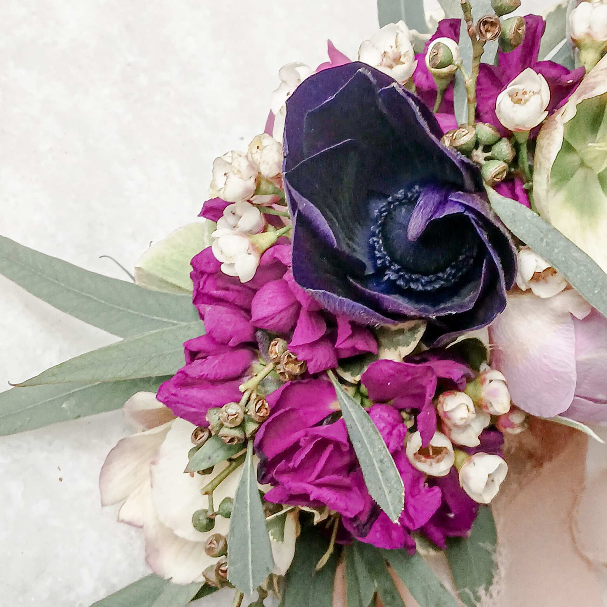 Purple and white bouquet with eucalyptus and a dark calla lily