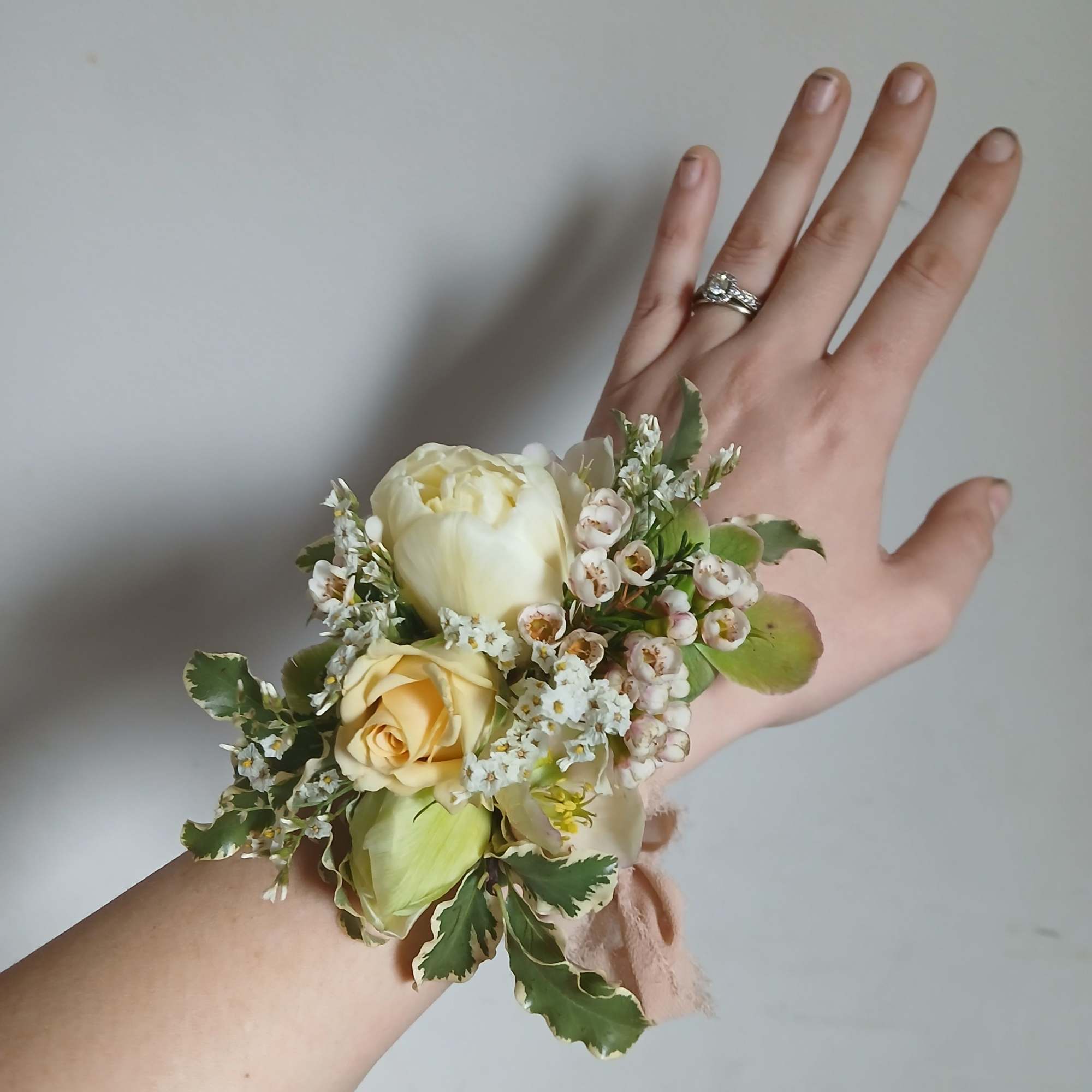 Cream rose wrist corsage with small white filler flowers