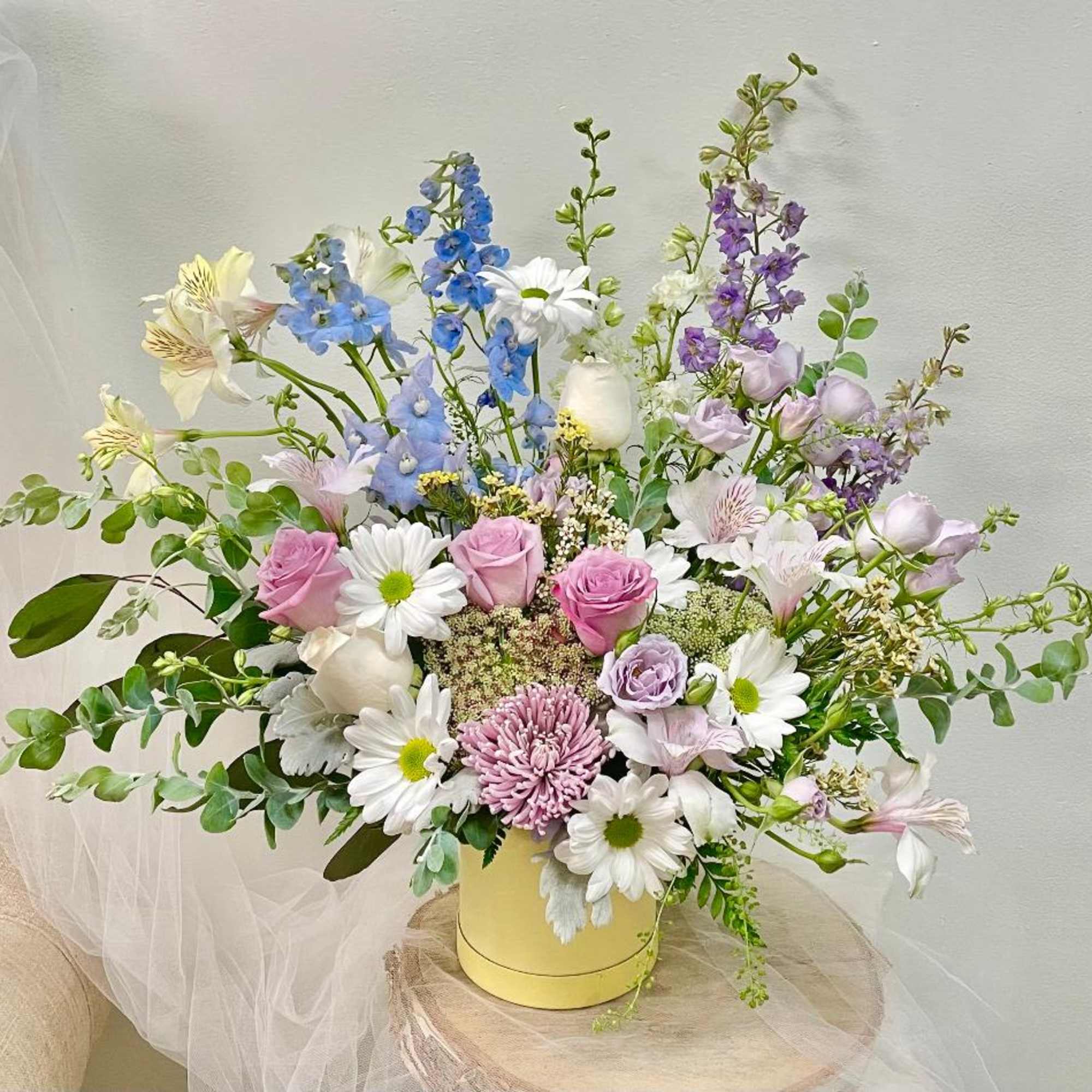 Pastel mixed flower arrangement in a yellow vase