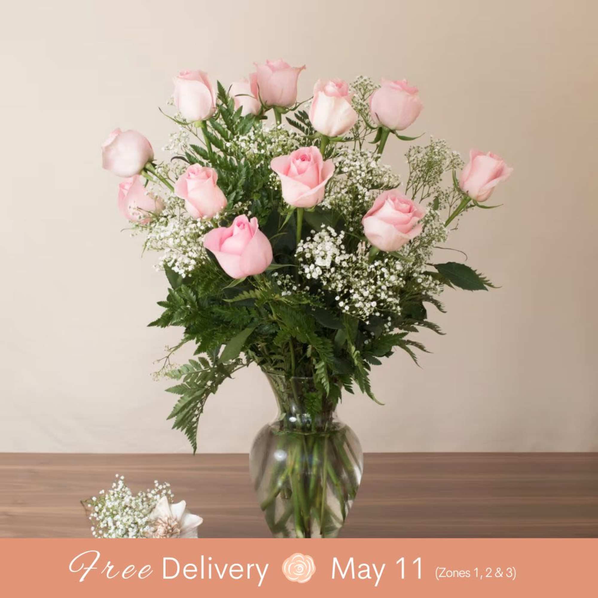 Pink roses in a glass vase with baby's breath