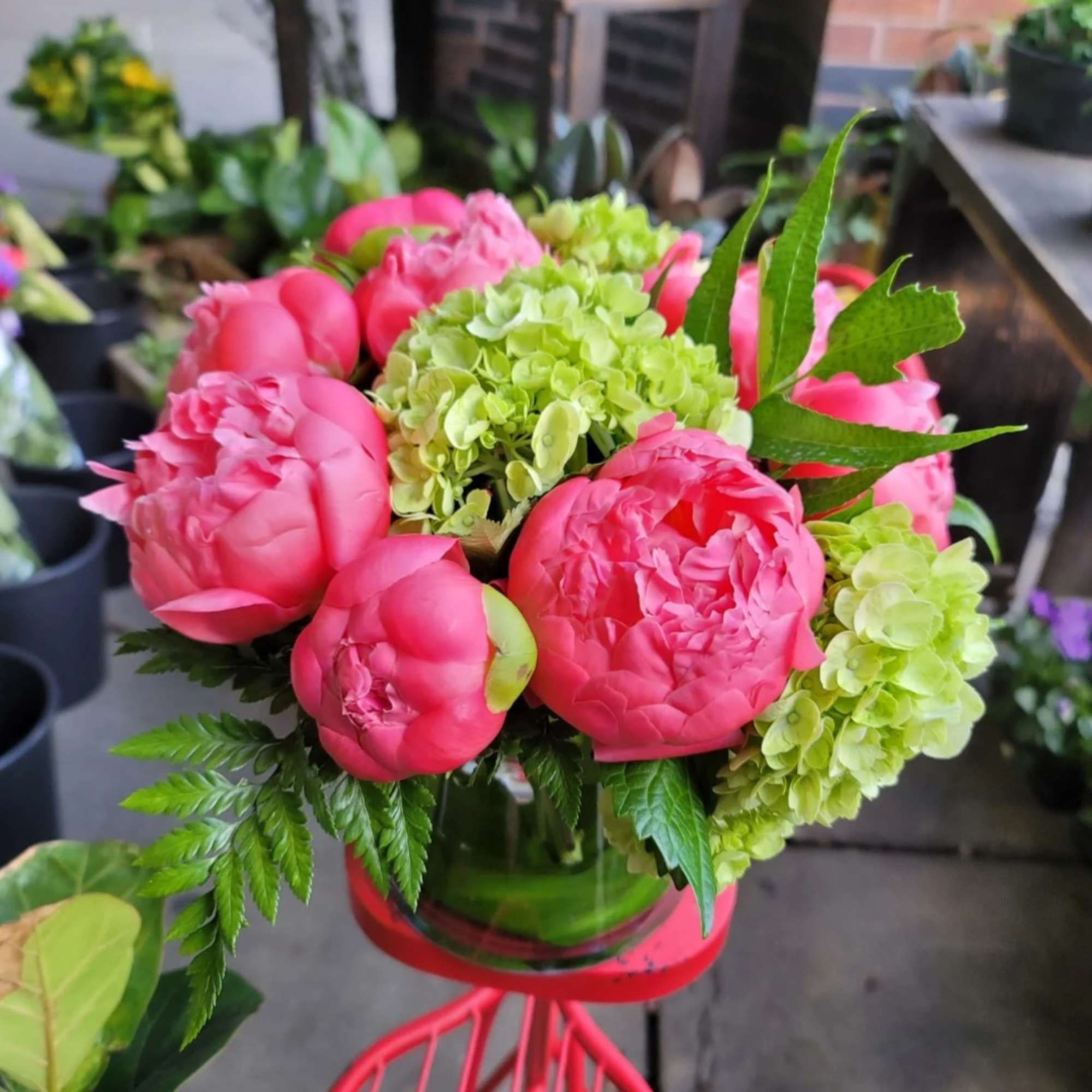 an elegant arrangement of pink  peonies with a small touch of