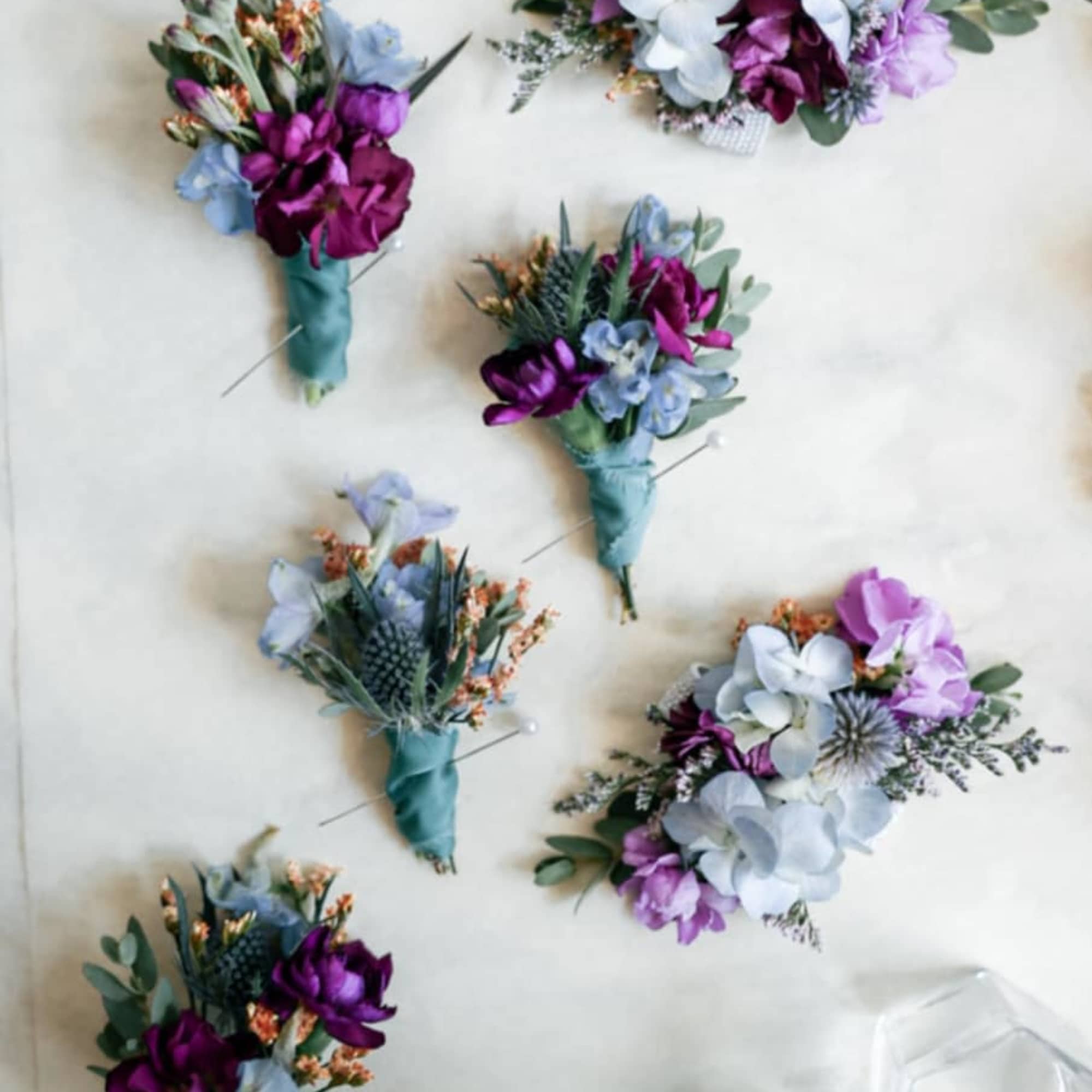 Small purple and blue boutonnieres with wrapped stems