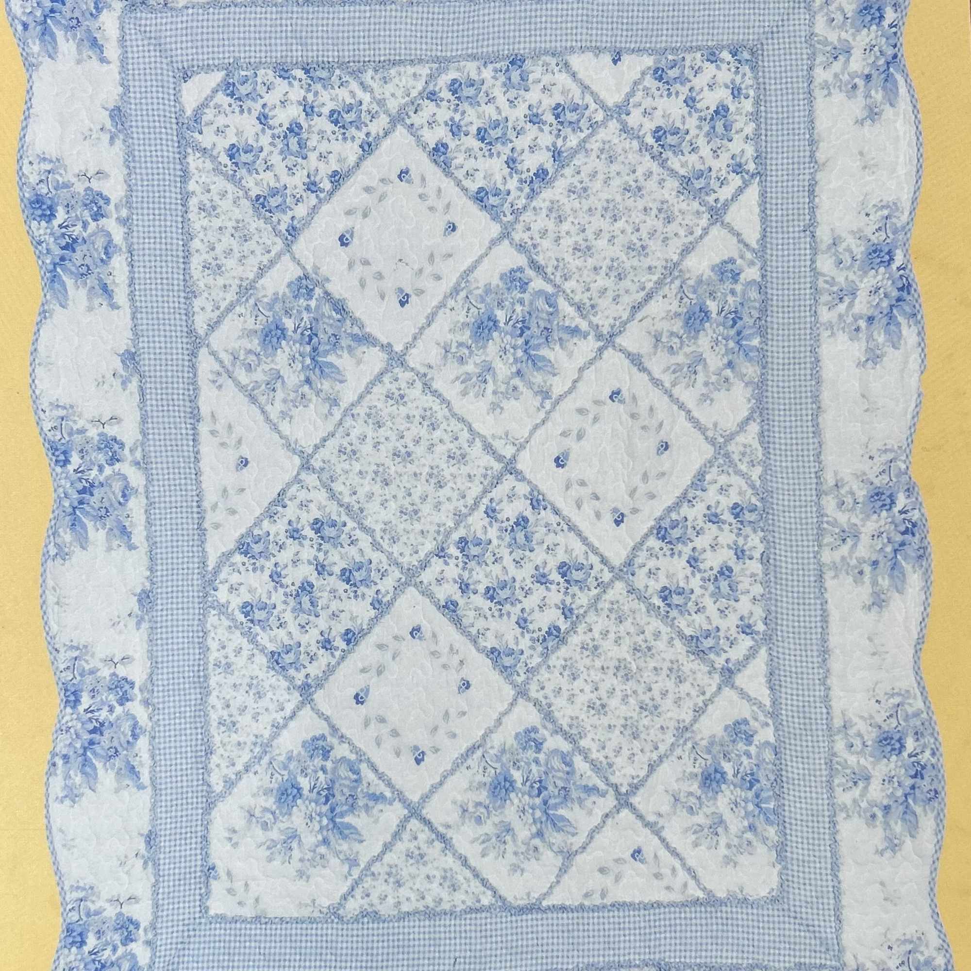 Blue and white quilted pillow with floral patchwork pattern