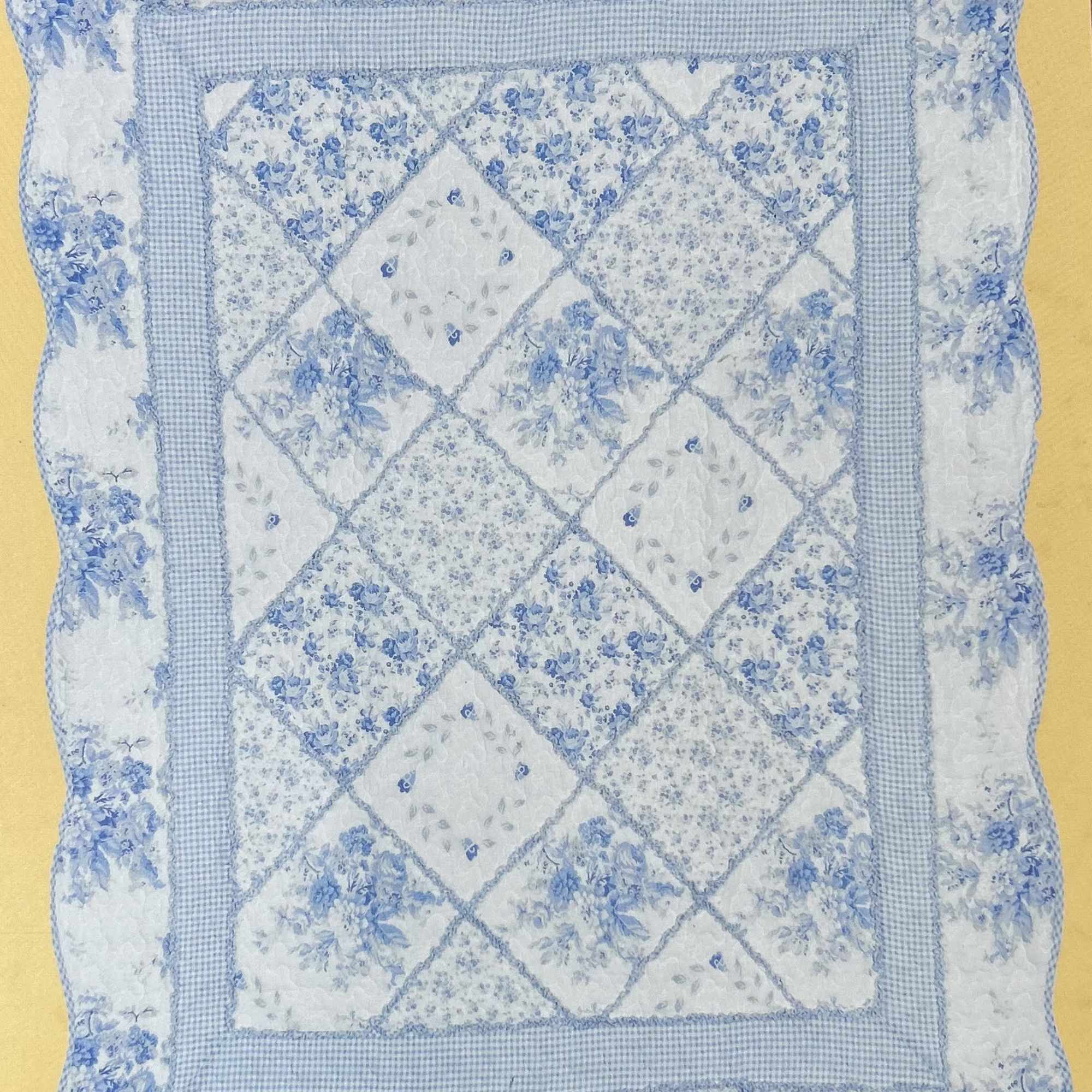 Blue and white quilted pillow with floral patchwork pattern