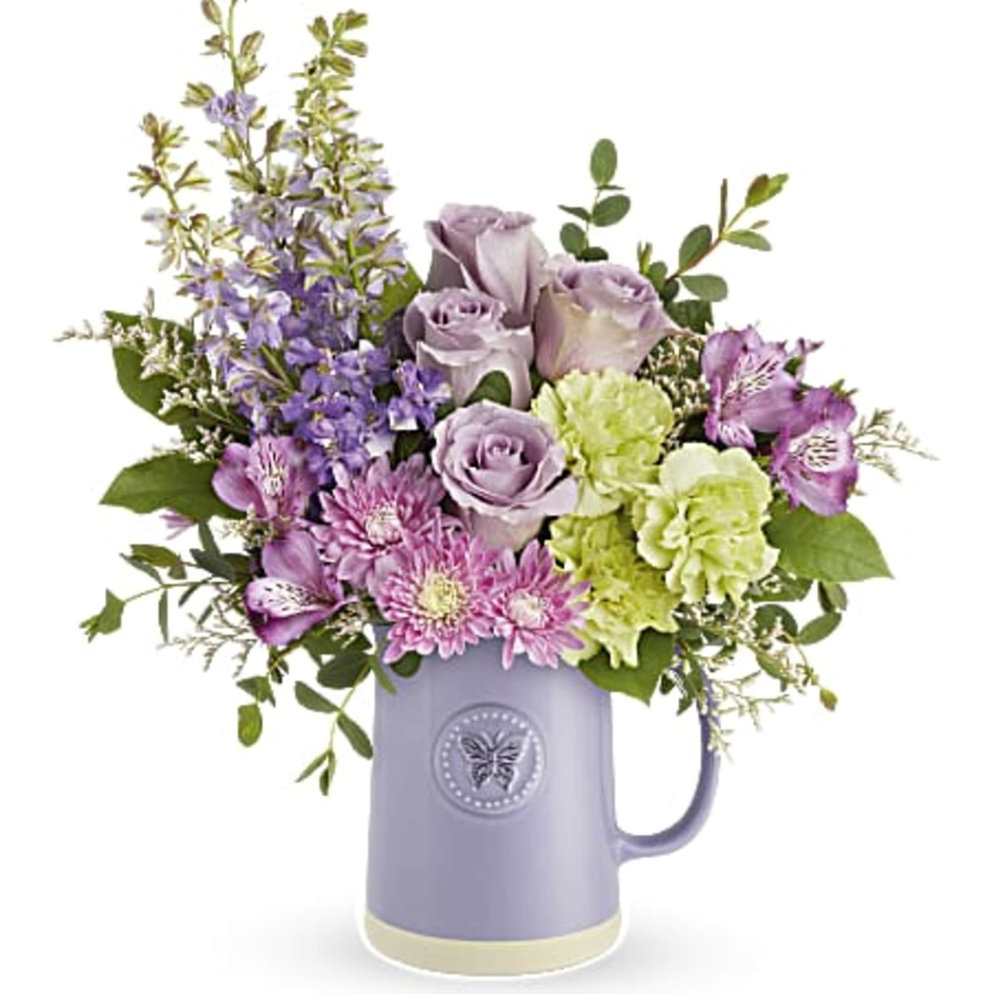 Lavender and pink bouquet in a purple ceramic pitcher vase