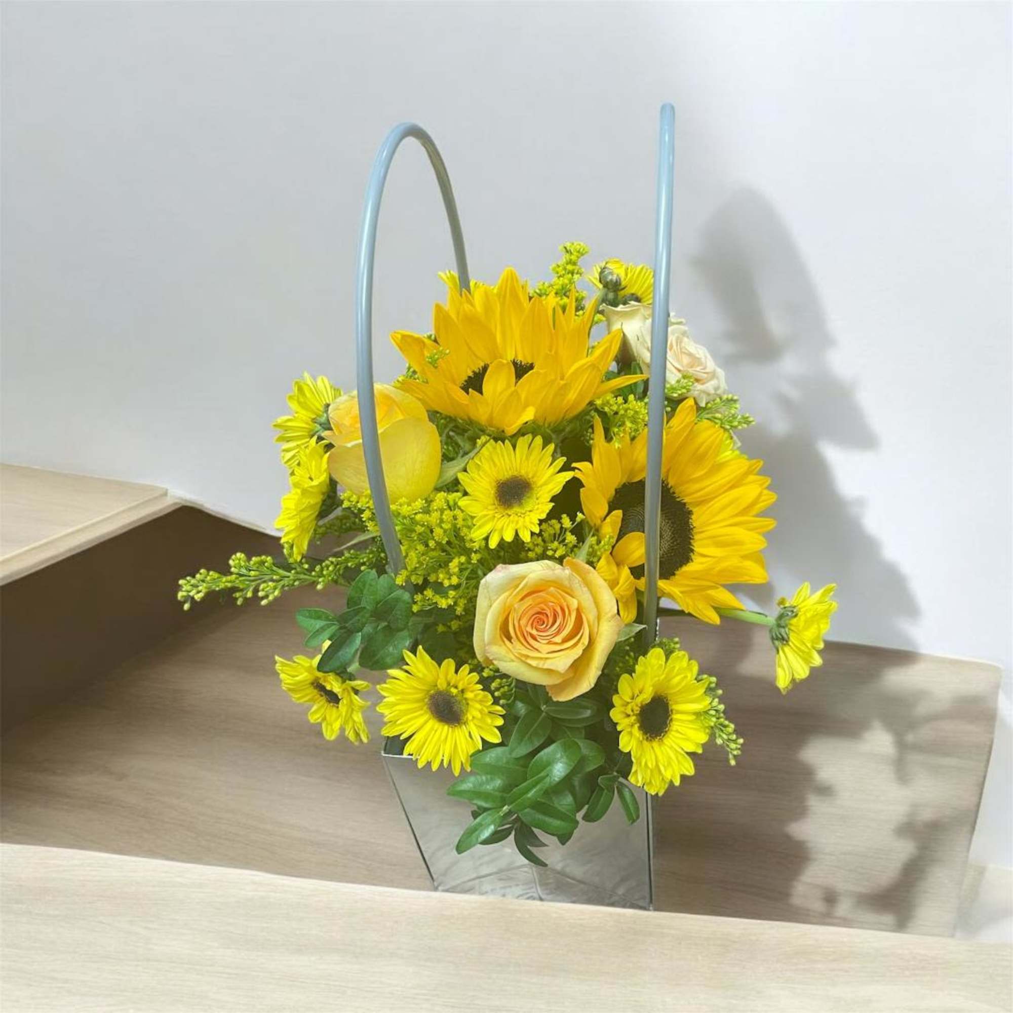 Yellow sunflower and rose arrangement in a metal basket