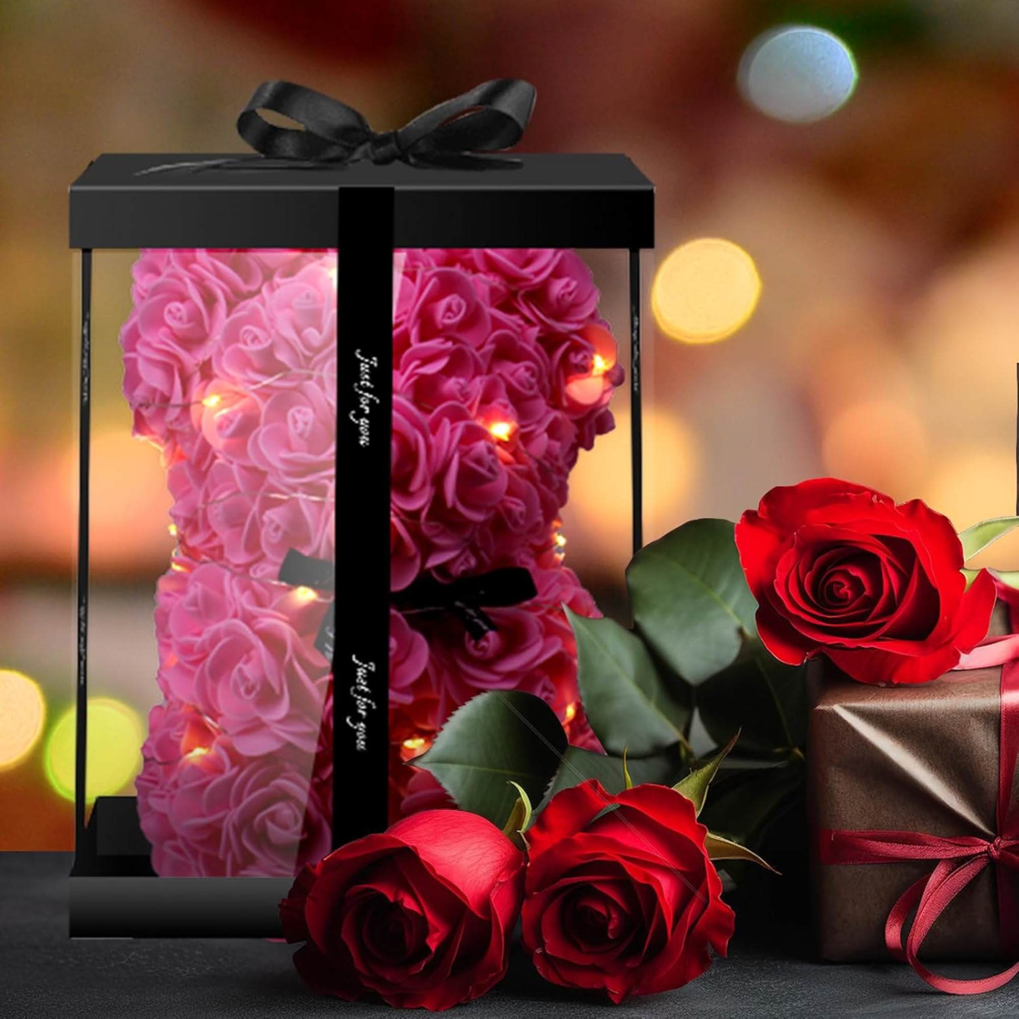 Pink rose teddy bear in a black gift box with red roses and a wrapped present