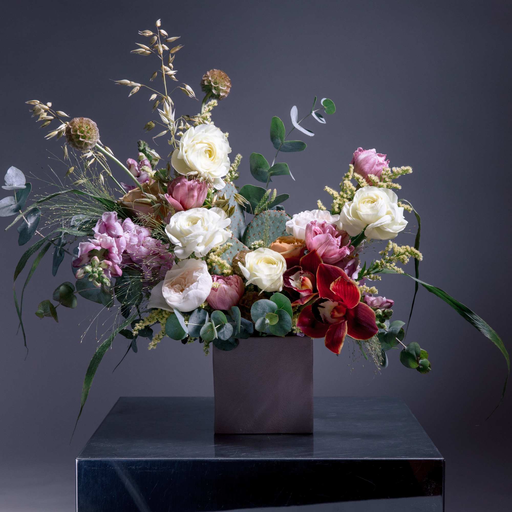 A sculptural, garden-style flower arrangement that pairs classic roses and tulips with