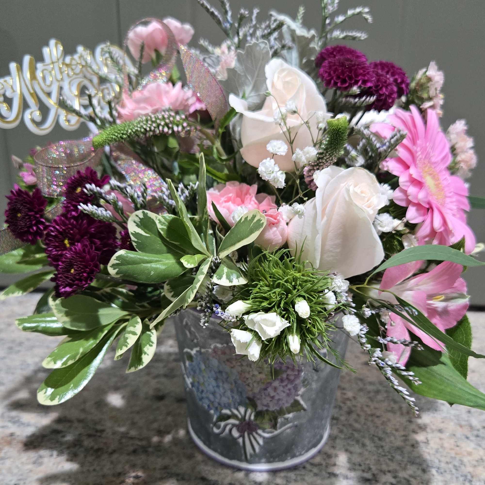 Pale pink roses and bright pink gerbera daisies meet deep purple chrysanthemums