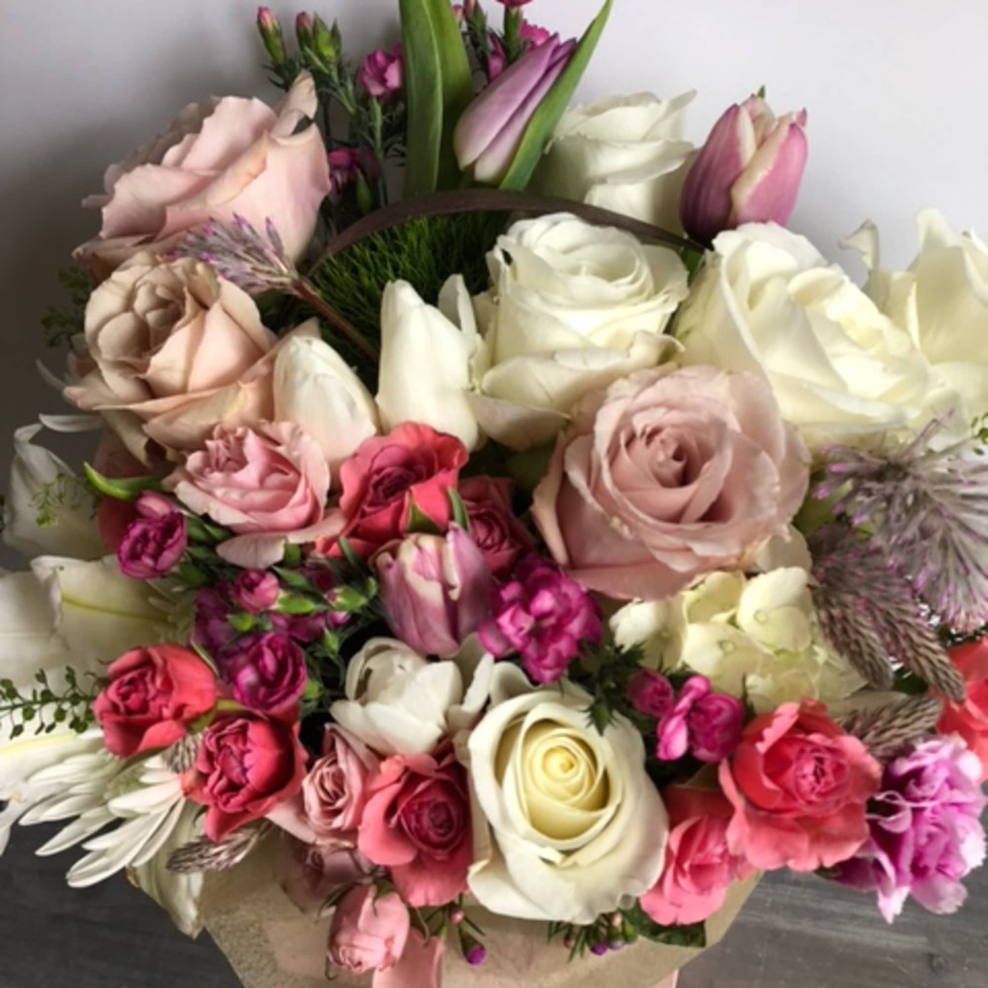 Mixed bouquet of pink and white roses with tulips and small purple flowers