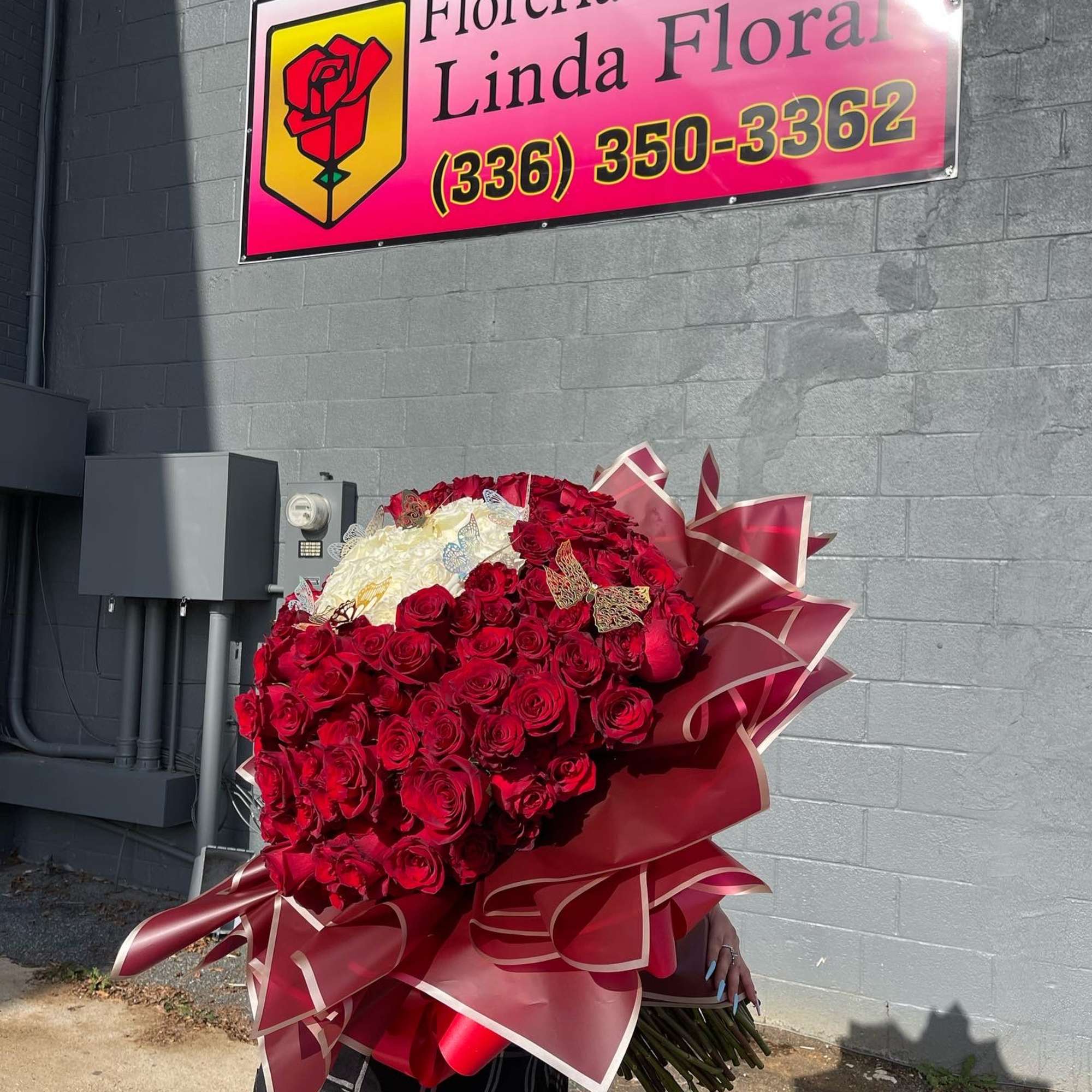 Large bouquet of red and white roses wrapped in burgundy paper