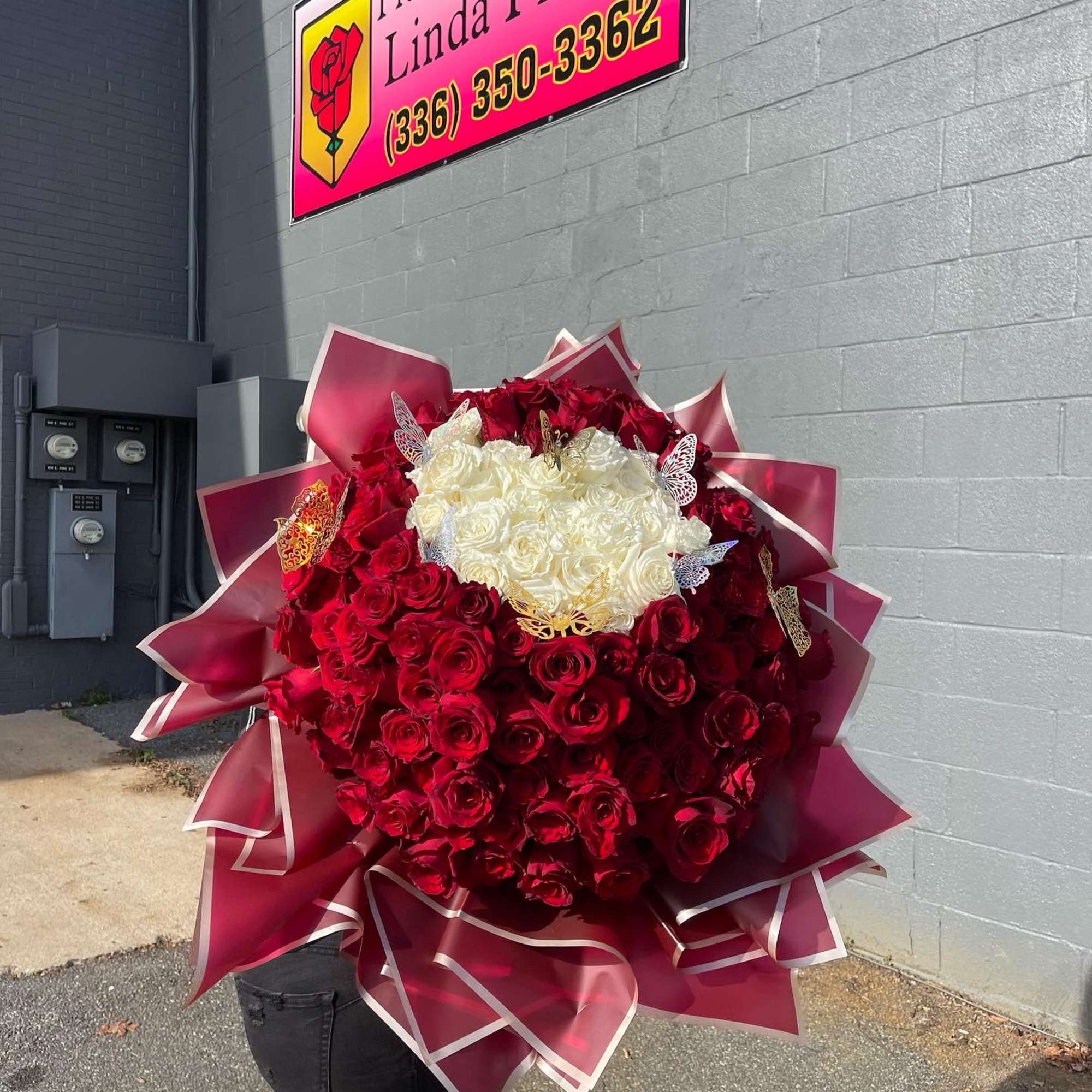 Large bouquet of red and white roses with decorative butterflies