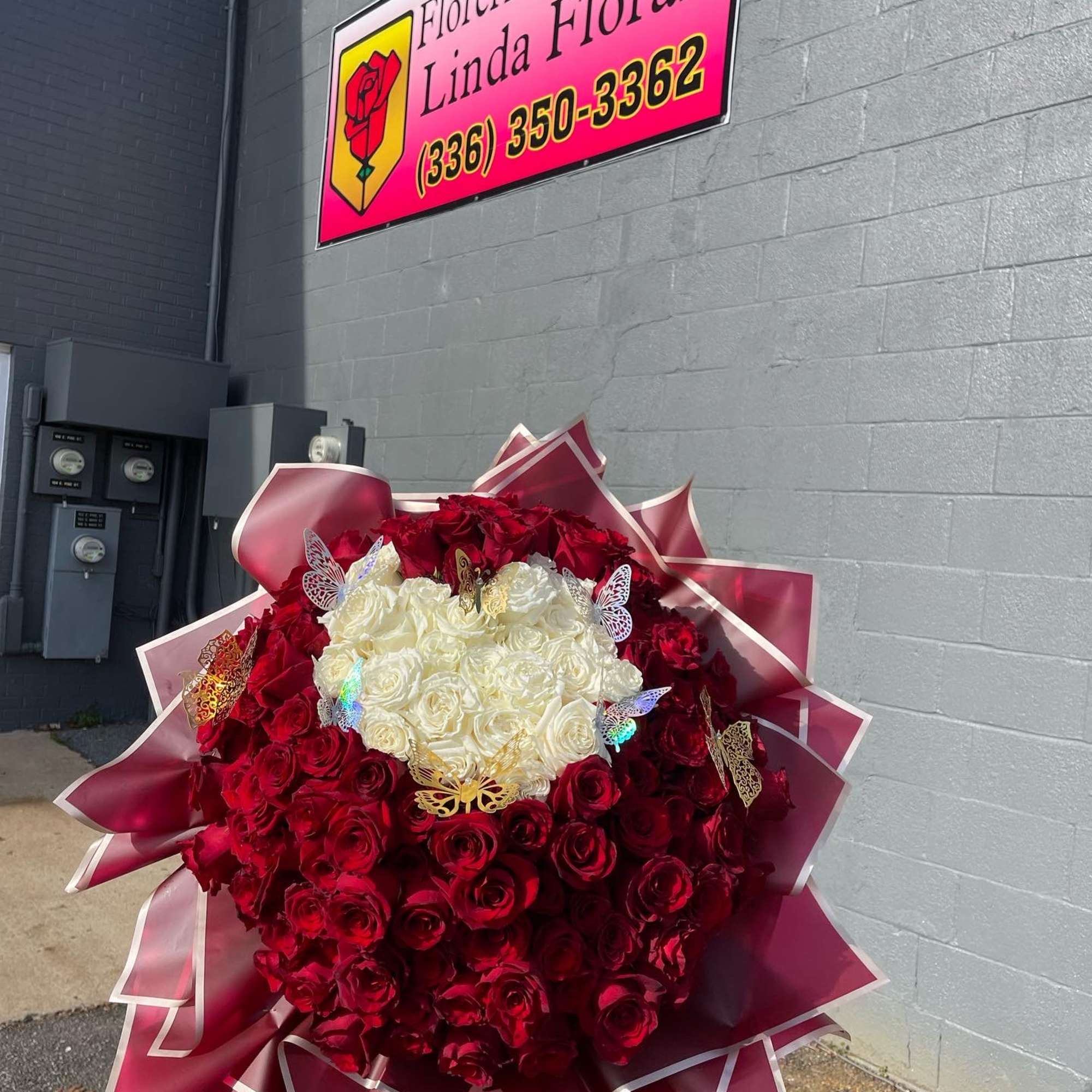 Large bouquet of red and white roses with decorative butterflies