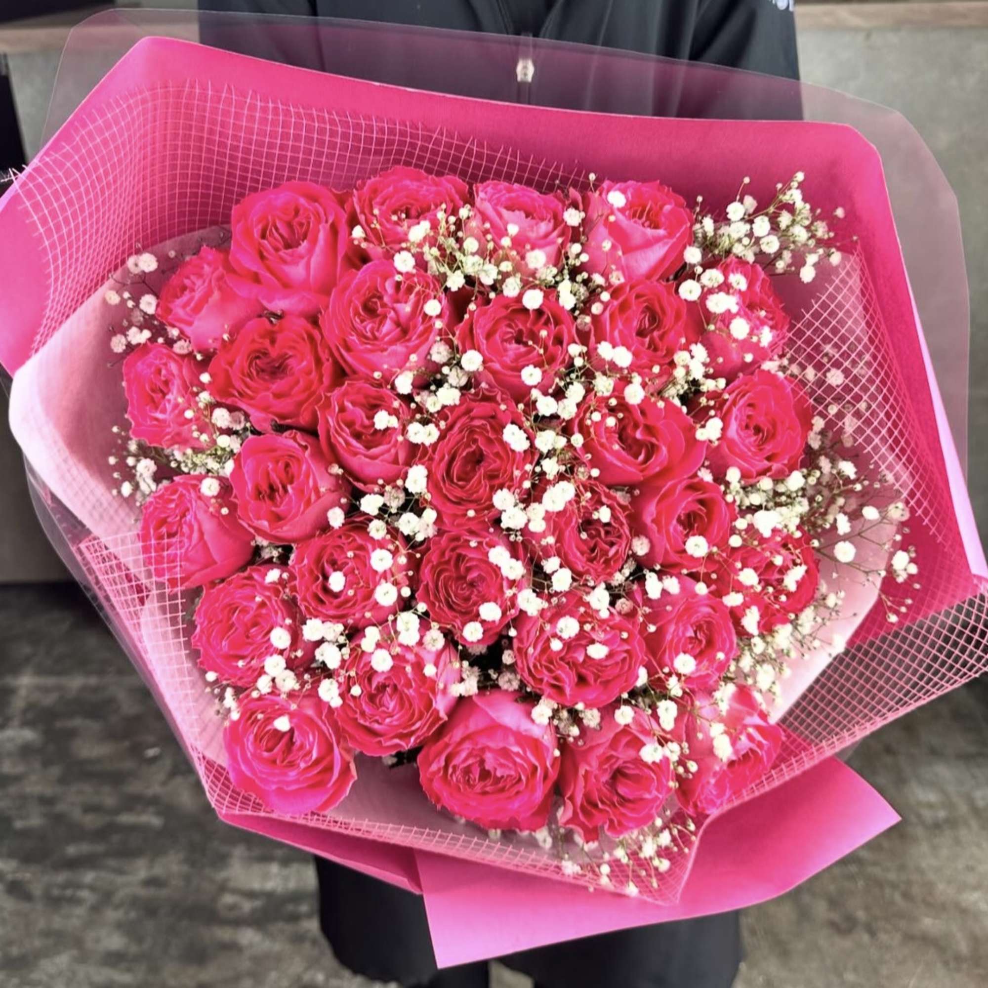Bouquet of hot pink roses with baby's breath wrapped in pink paper