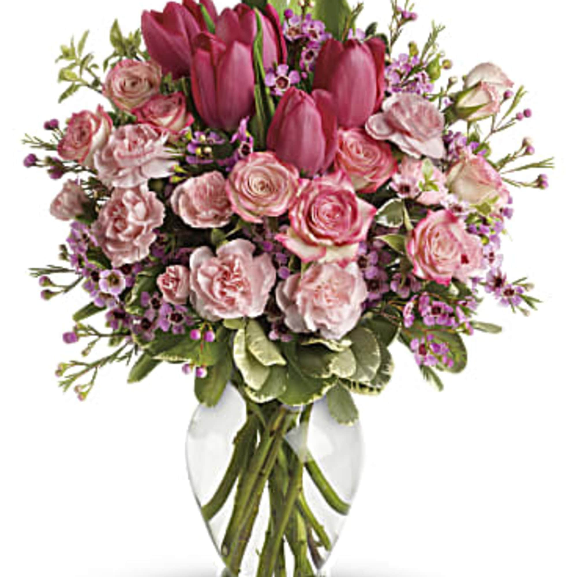 Pink tulips and roses arranged in a clear glass vase