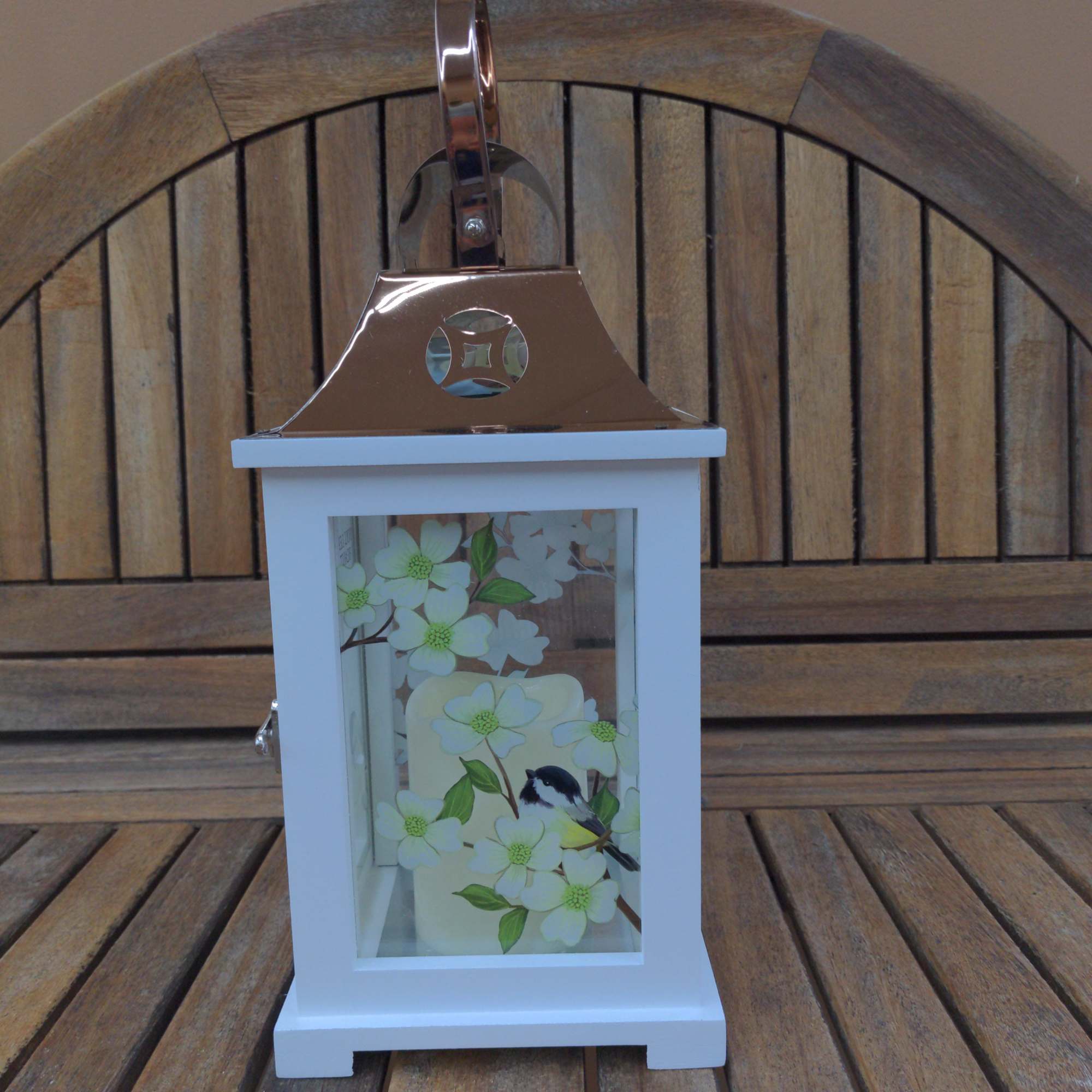 White lantern with floral bird design and a copper handle