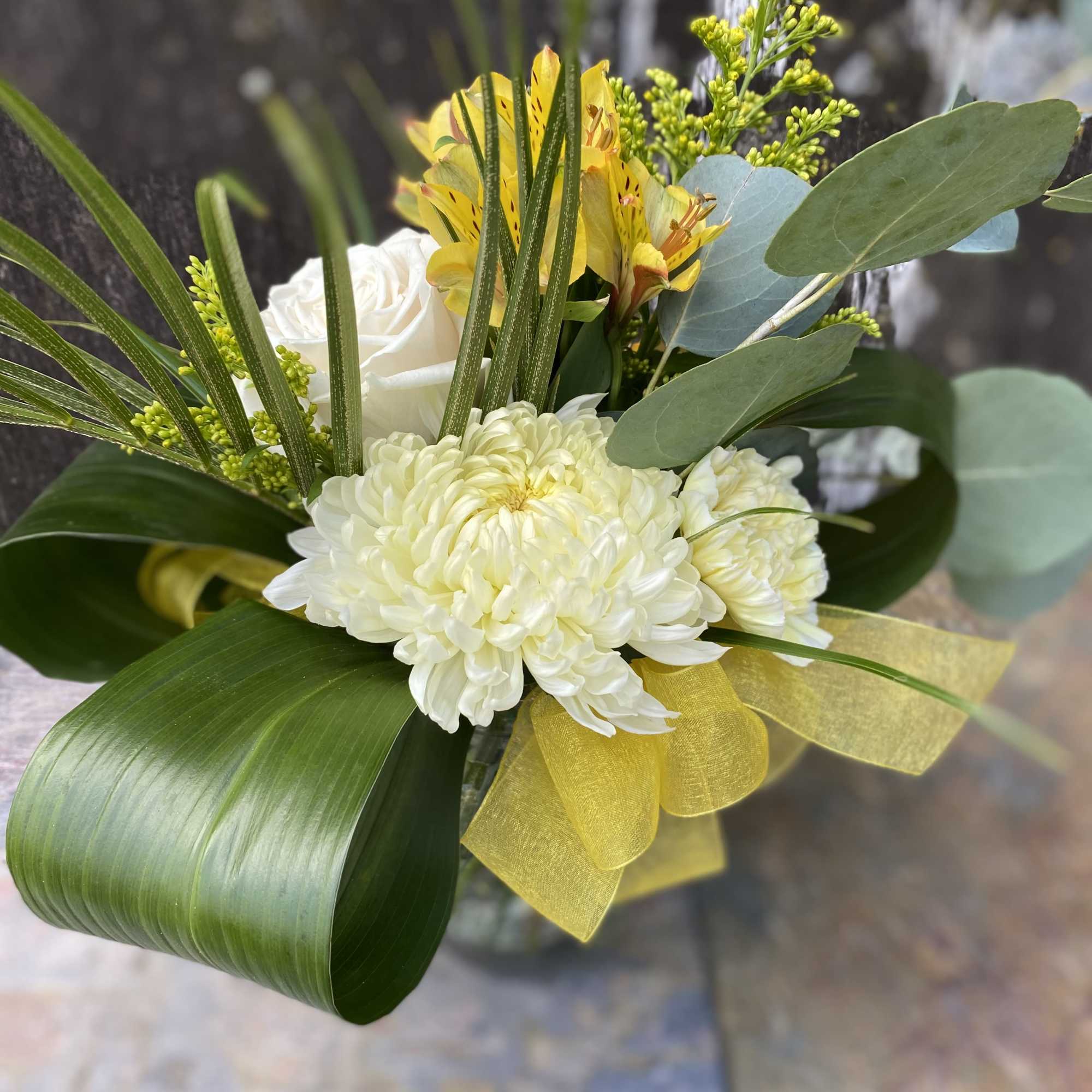 Bouquet of white chrysanthemums and yellow alstroemeria with green foliage
