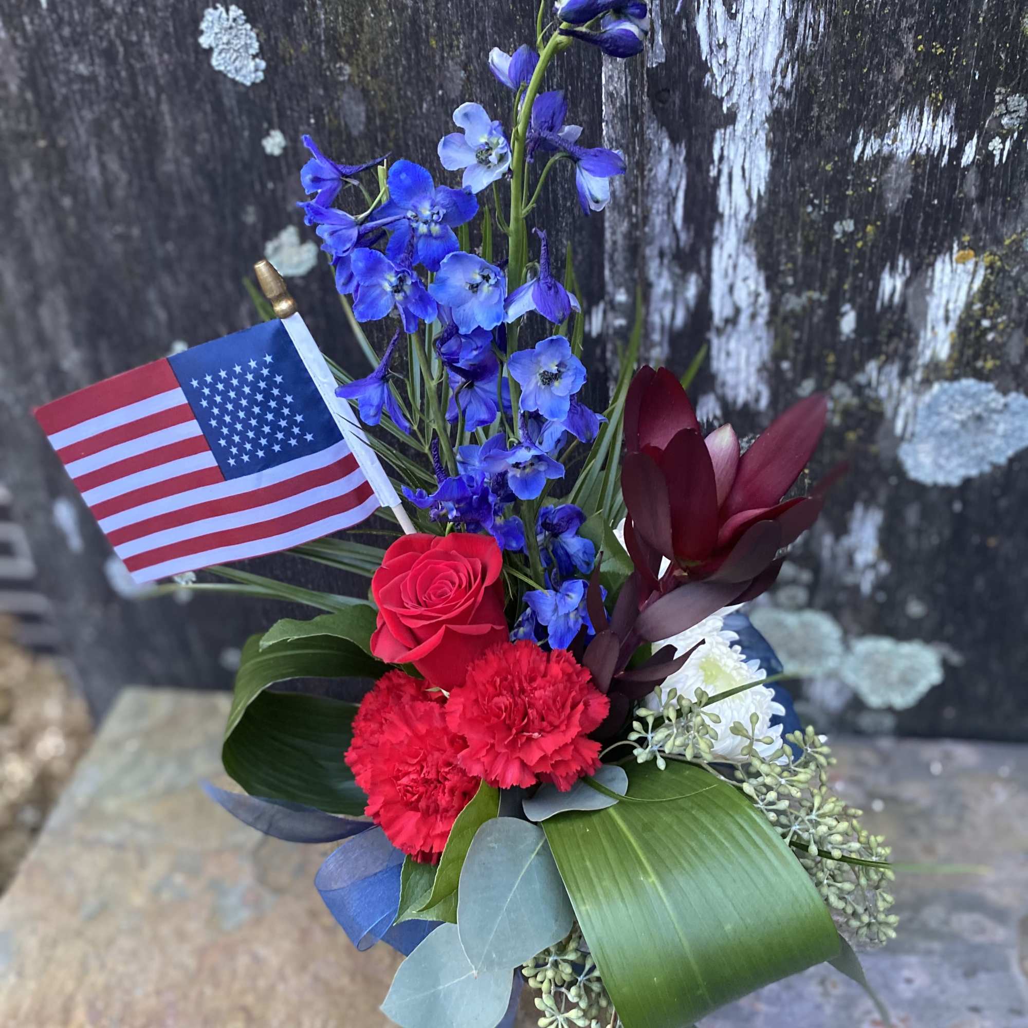 Red, blue, and white floral arrangement with an American flag