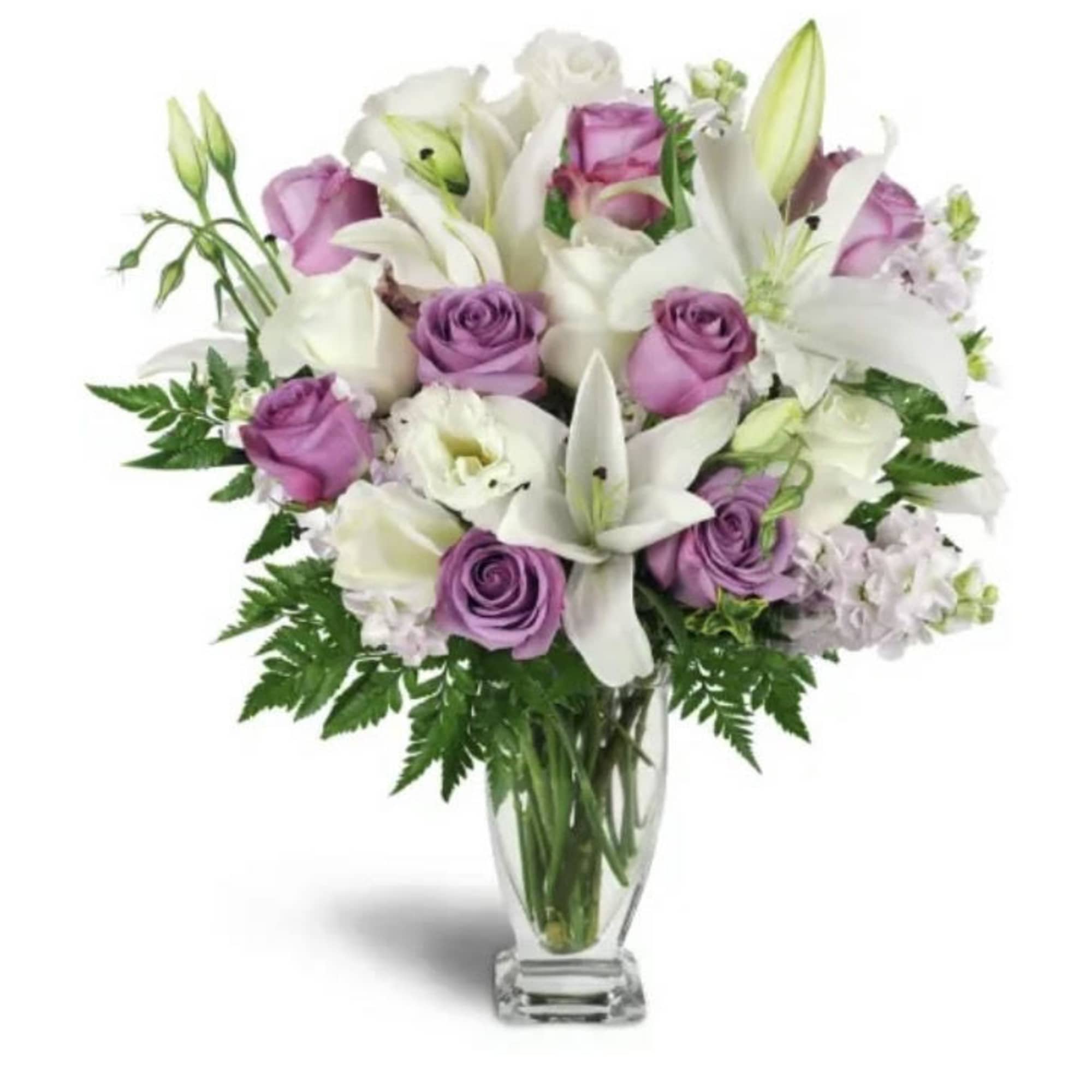 Bouquet of white lilies and lavender roses in a clear glass vase