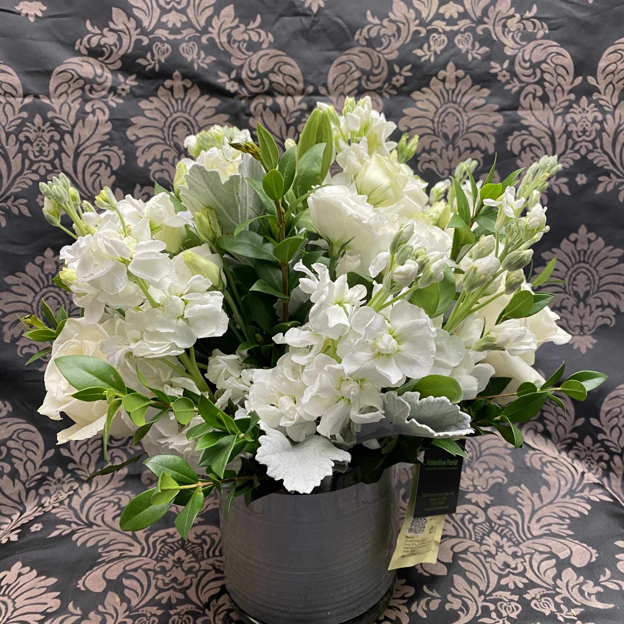 New beginnings deserve flowers! This all white arrangement includes roses, lisianthus and