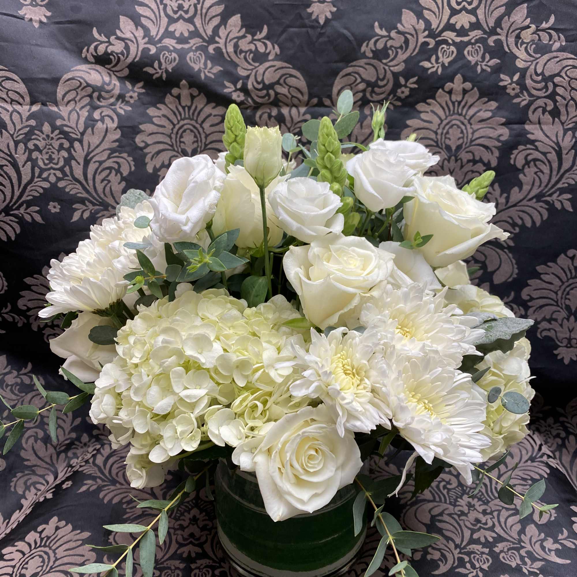 New beginnings deserve flowers! This all white arrangement includes roses, lisianthus and
