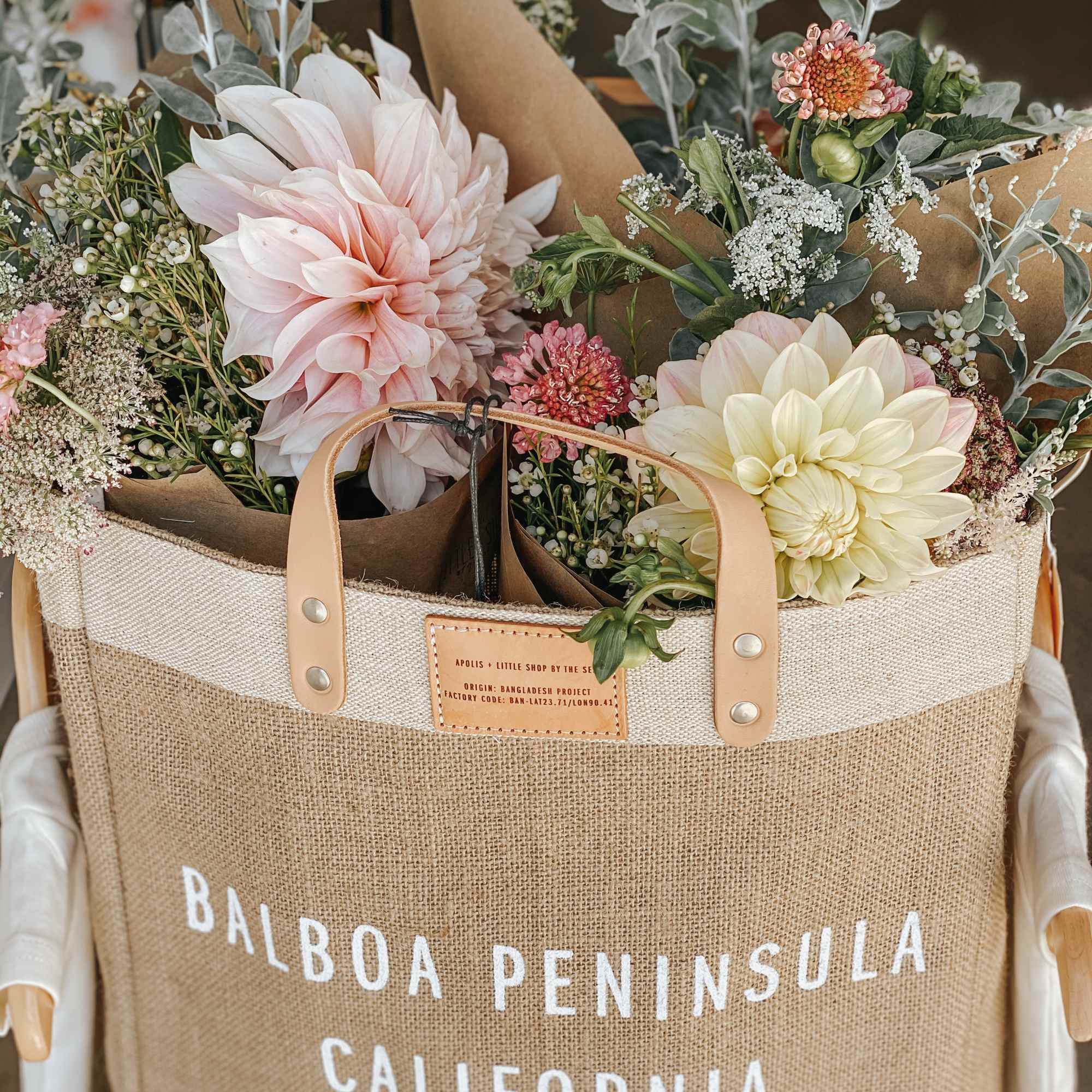 Two pastel flower bouquets in a burlap tote bag