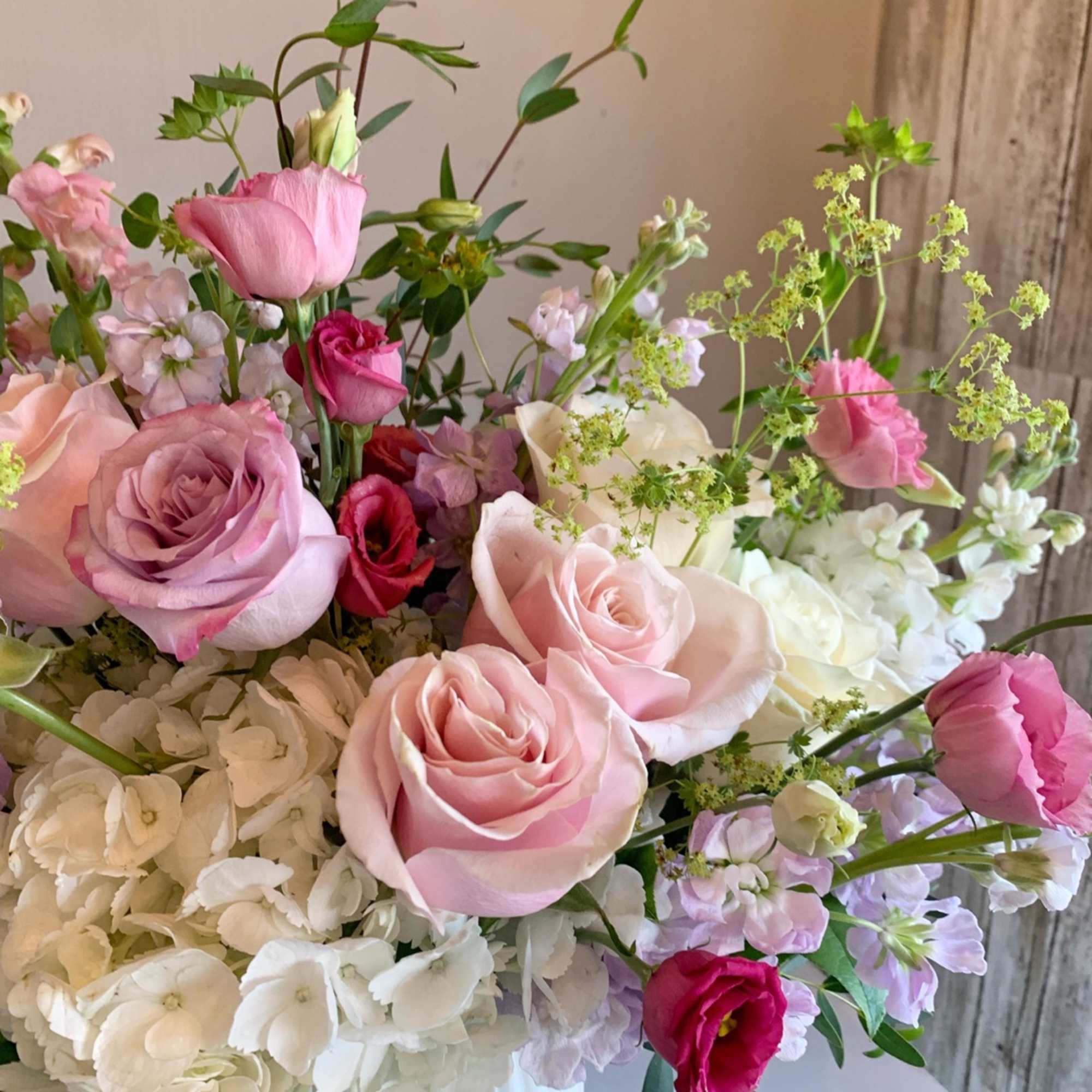 Pink and white rose bouquet with hydrangeas in a white vase