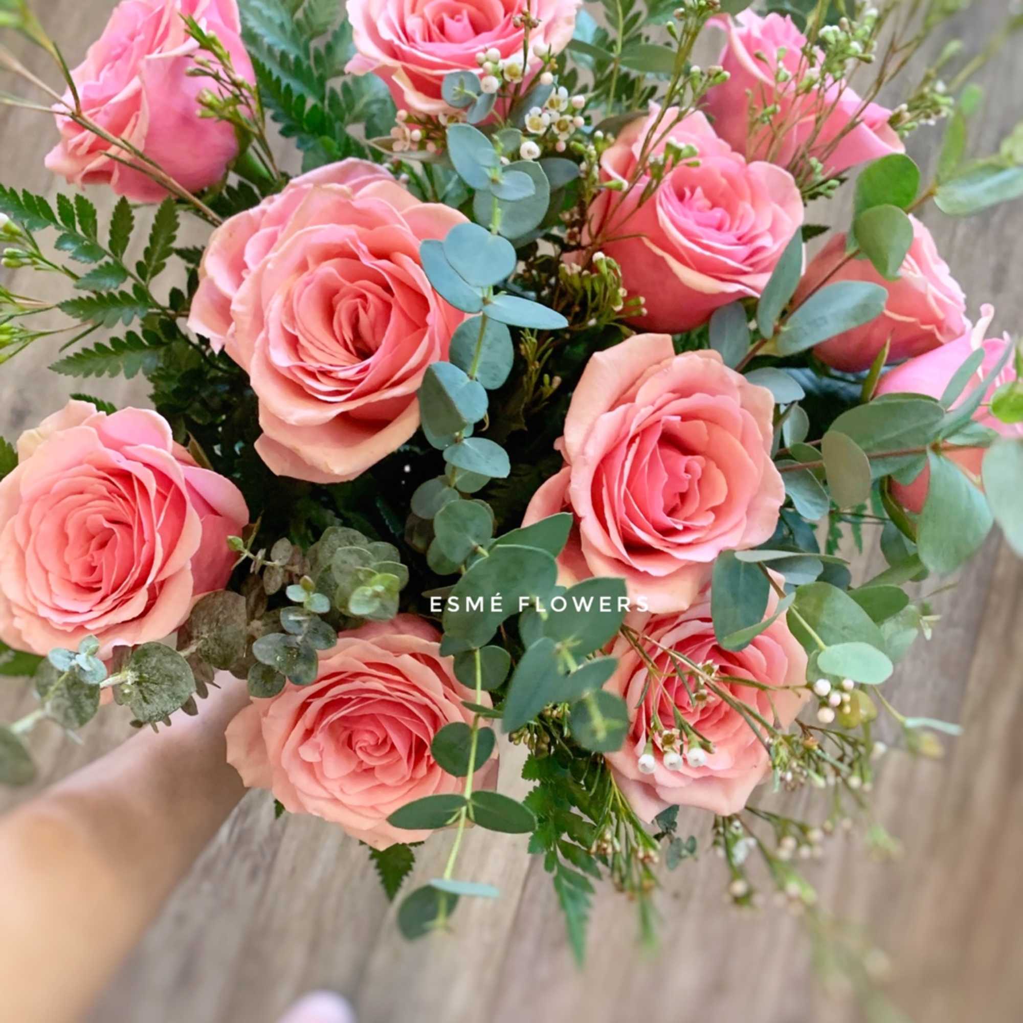 Bouquet of pink roses with eucalyptus and small white filler flowers