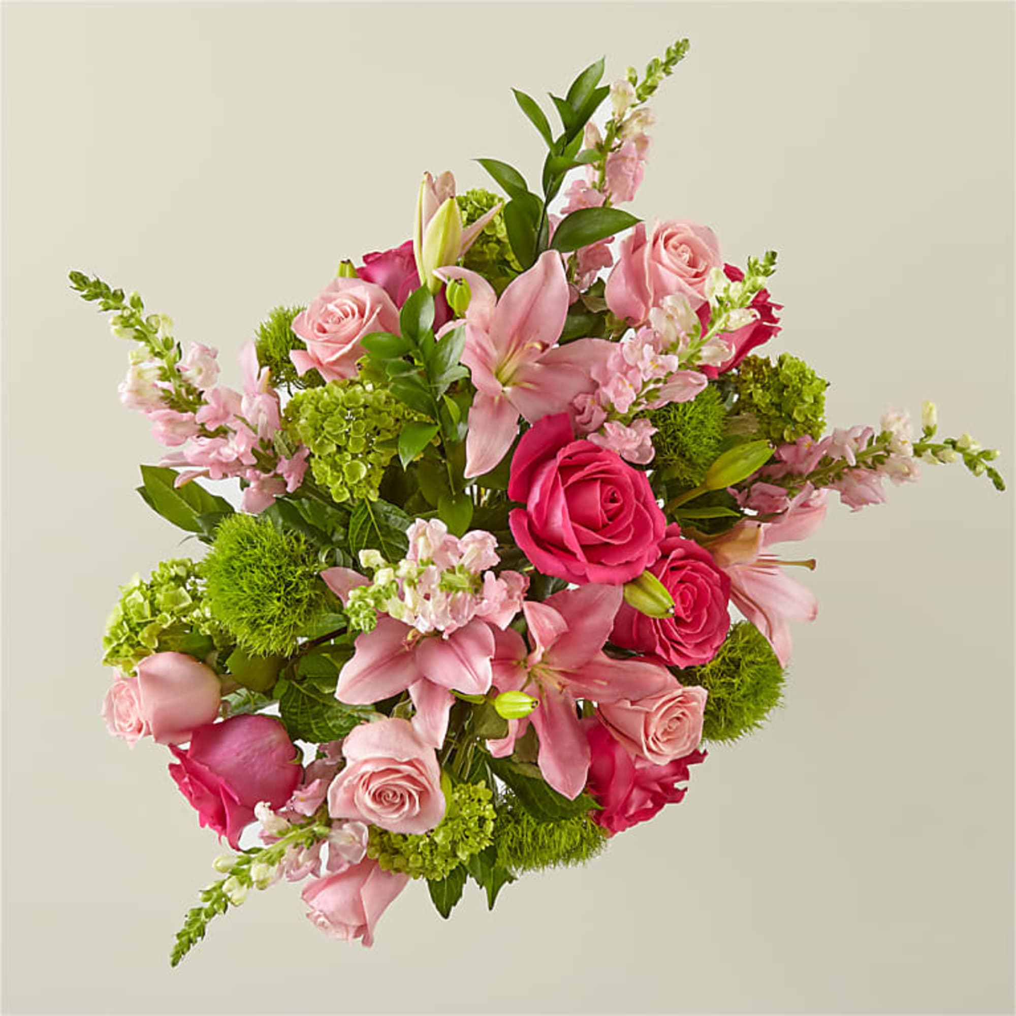 Pink roses and lilies arranged with green accents