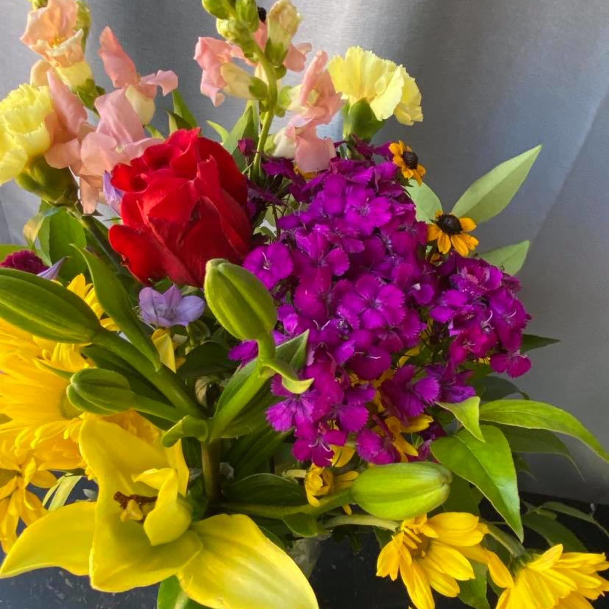 Bright mixed bouquet with yellow lilies, red rose, and purple flowers