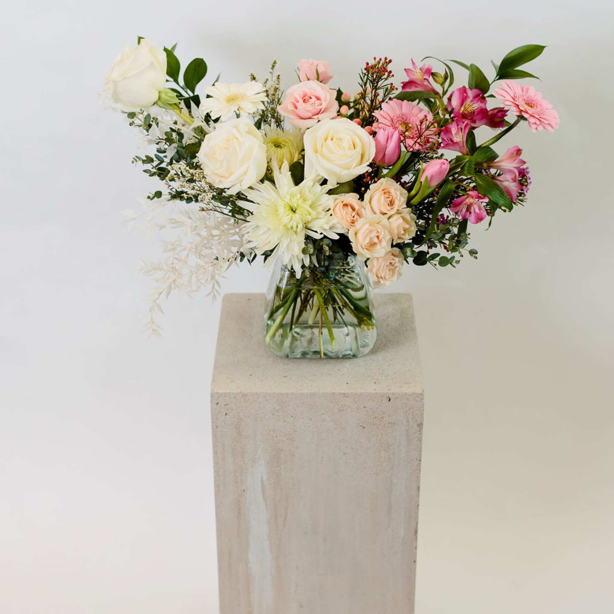 Mixed bouquet of pink and white flowers in a glass vase