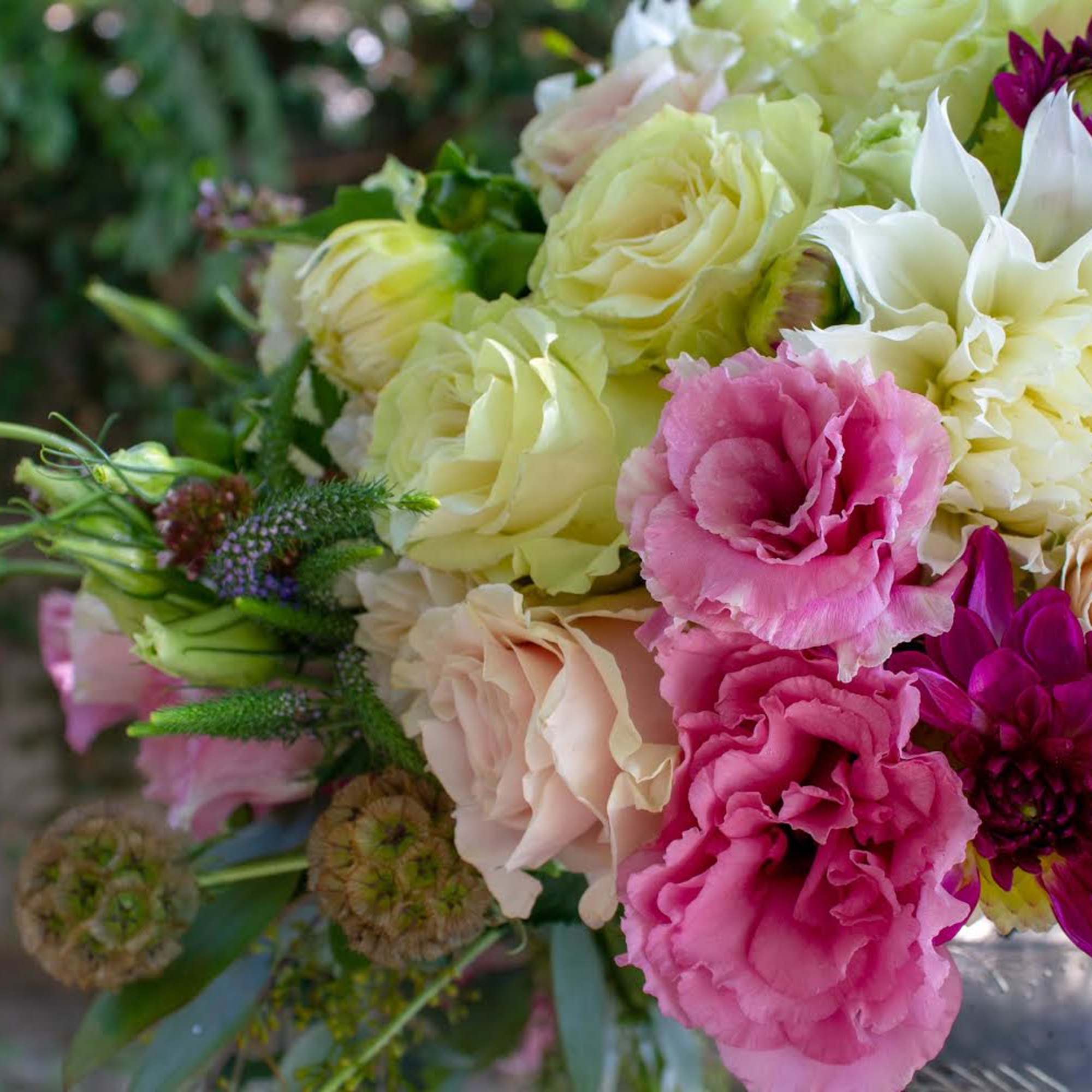 Mixed bouquet of pink, cream, and white flowers in a glass vase