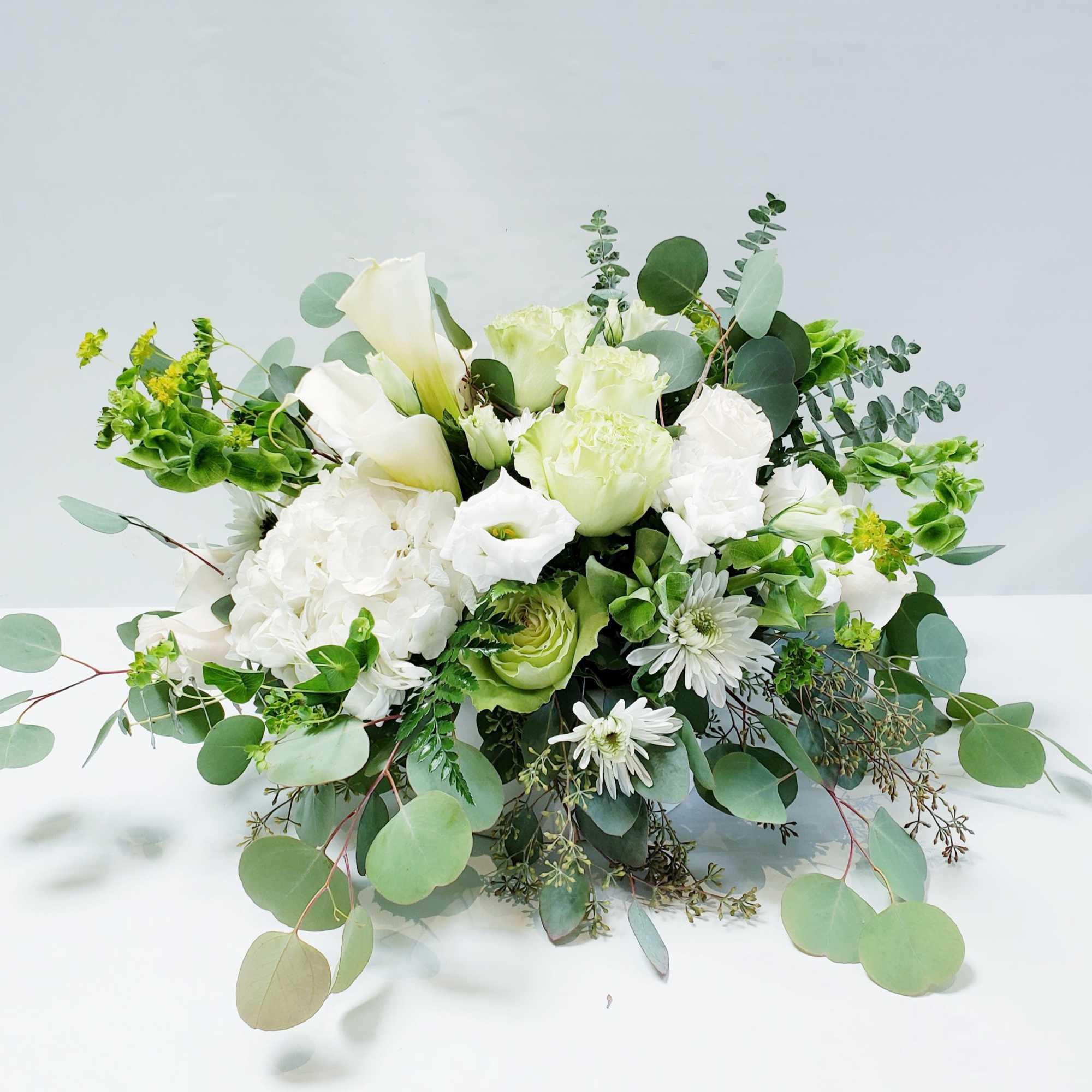 White floral arrangement with eucalyptus and green accents