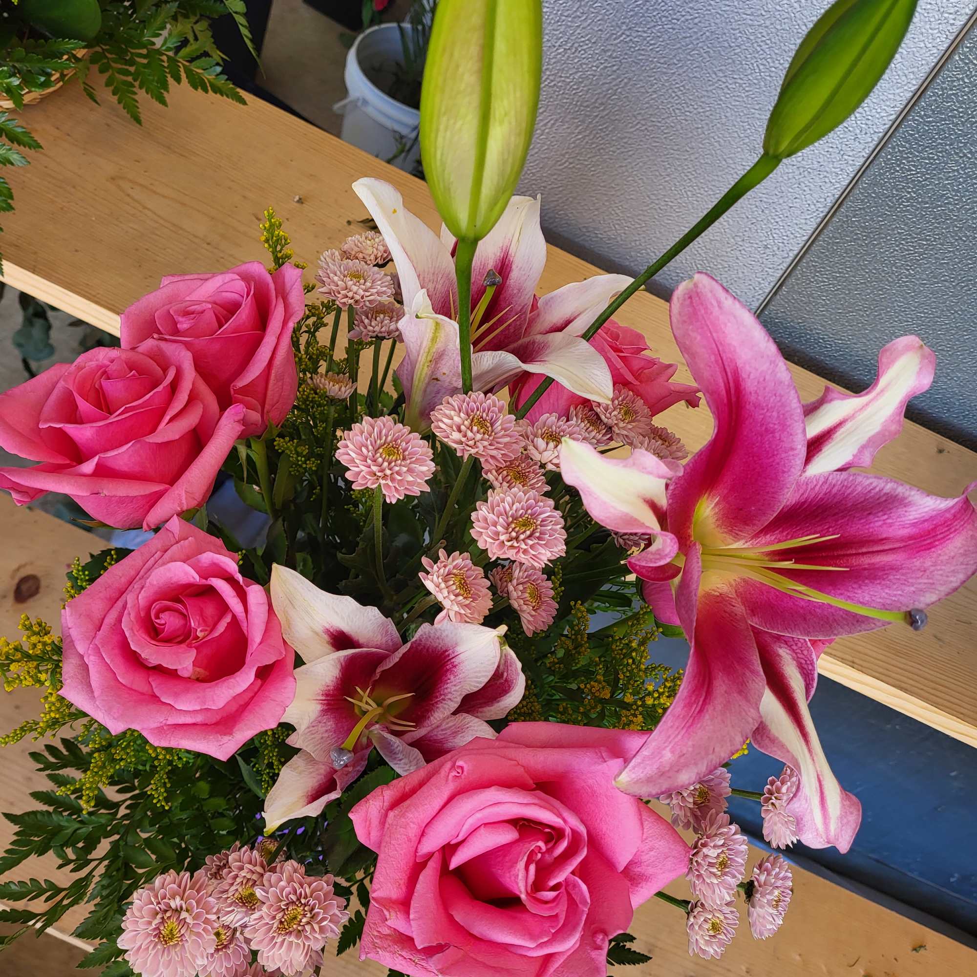Pink roses and lilies with small pink daisies in a bouquet