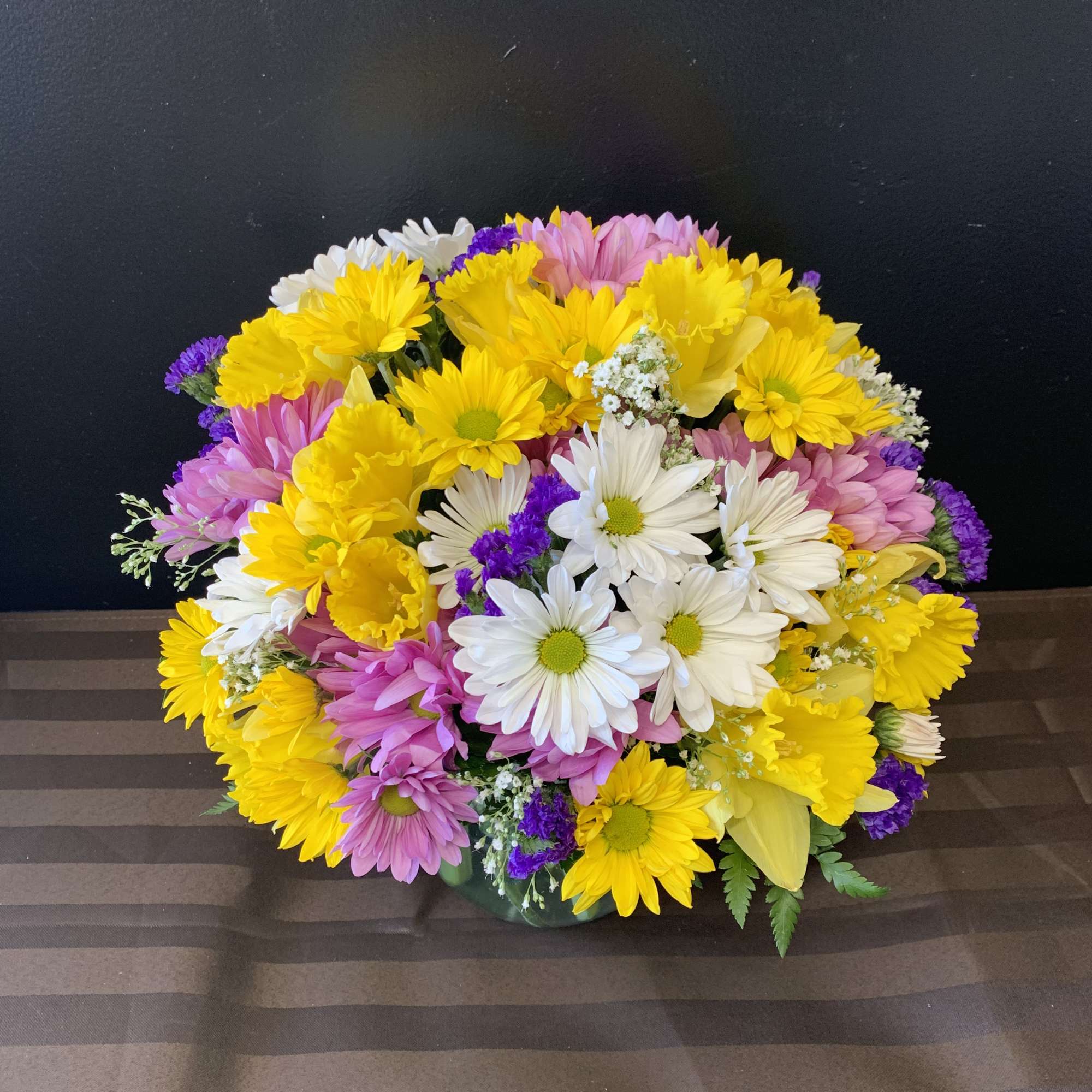 Mixed bouquet of yellow, white, pink, and purple daisies
