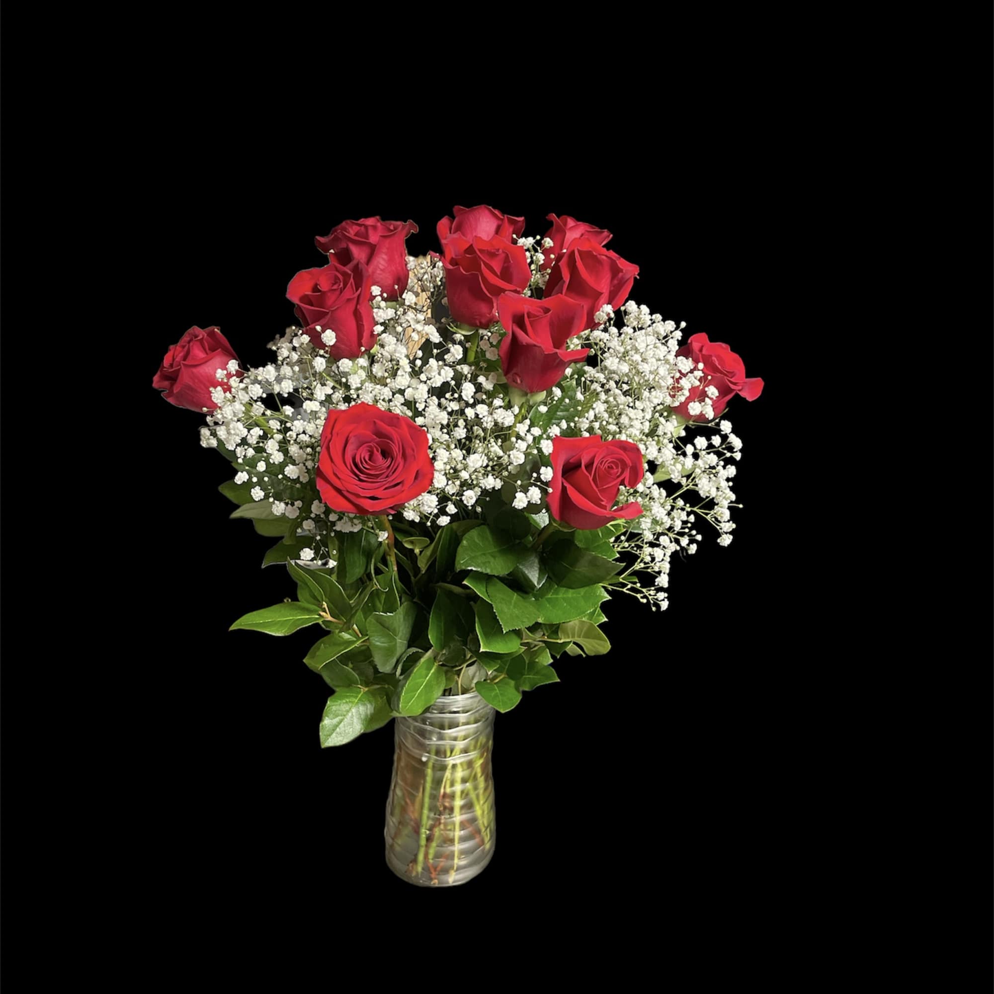 Red roses and baby's breath in a clear glass vase