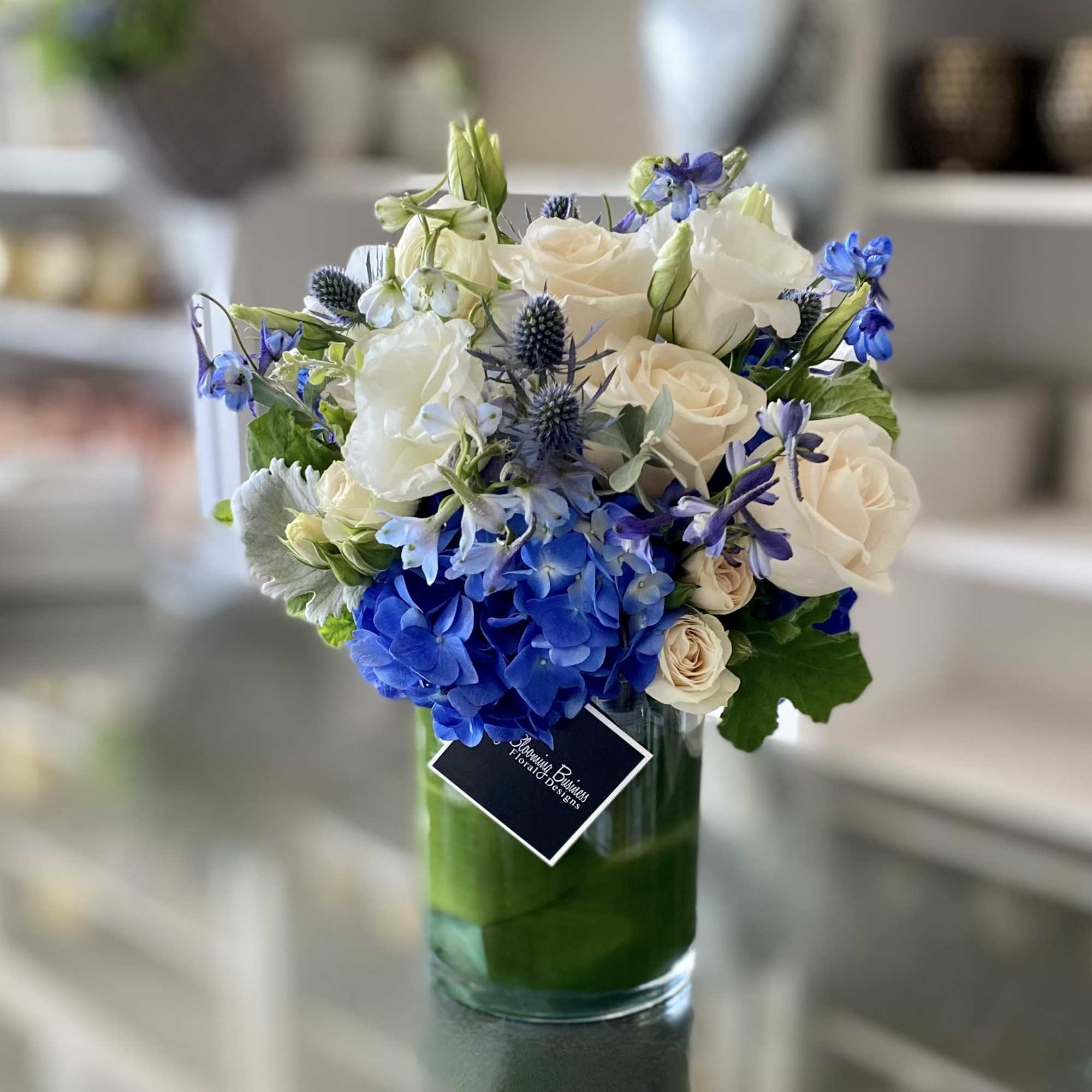 Blue and white floral arrangement in a glass vase
