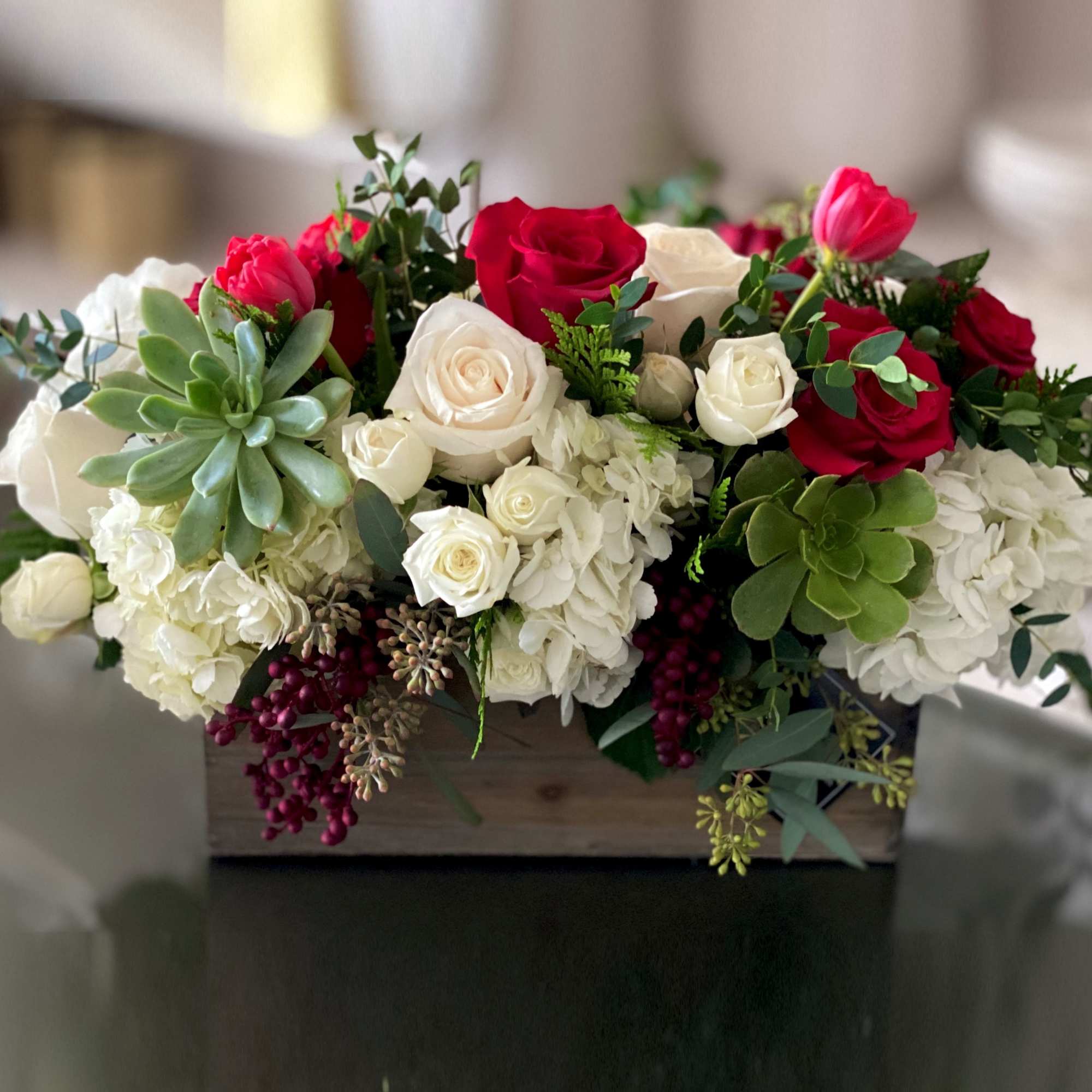 Mixed roses and hydrangeas in a wooden box with succulents