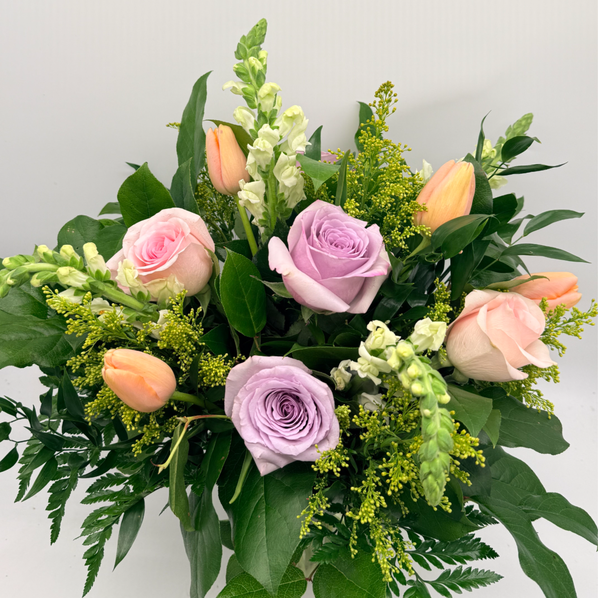 A sweet and stylish mix of roses, tulips, and fresh seasonal blooms.