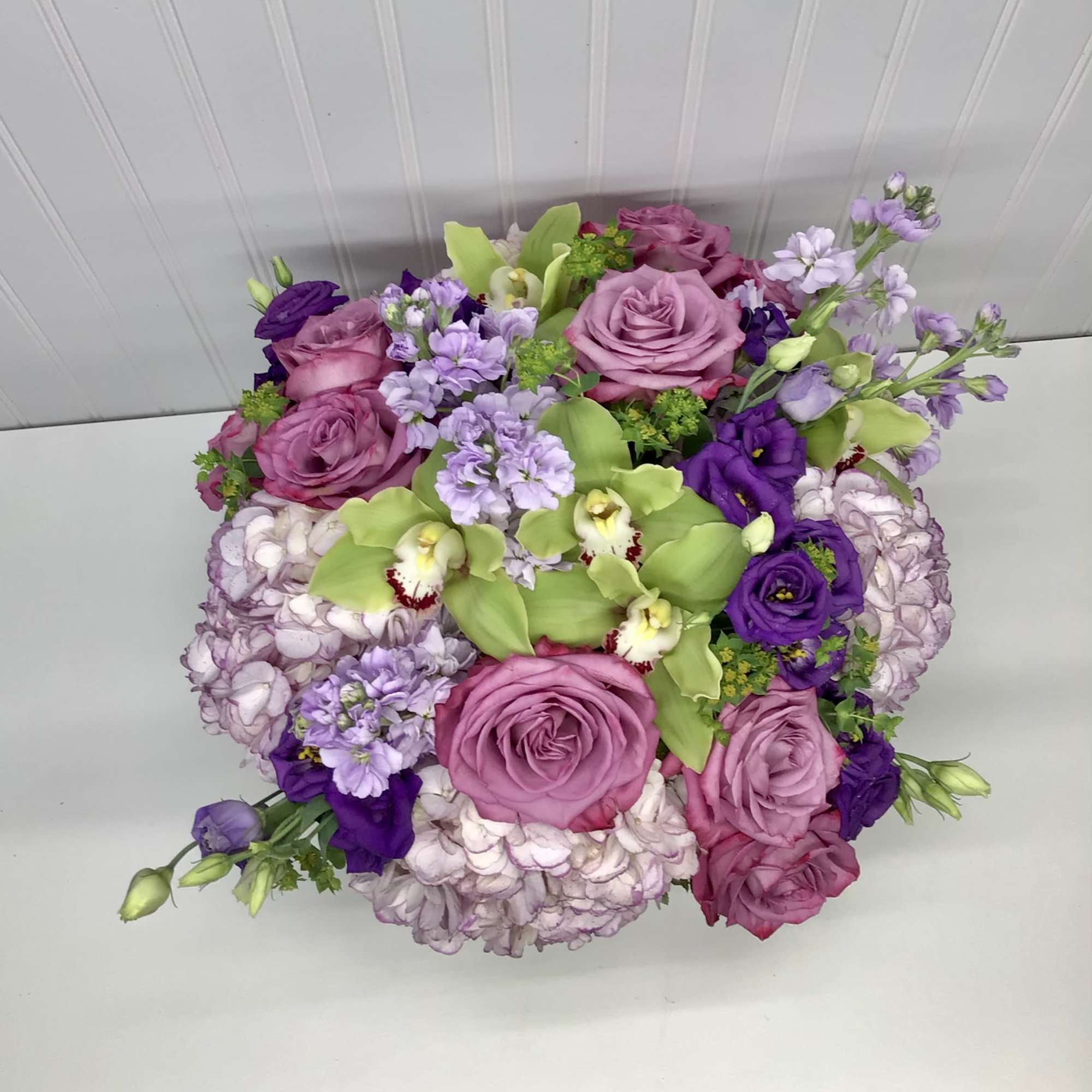 Bouquet of pink and purple flowers with green orchids