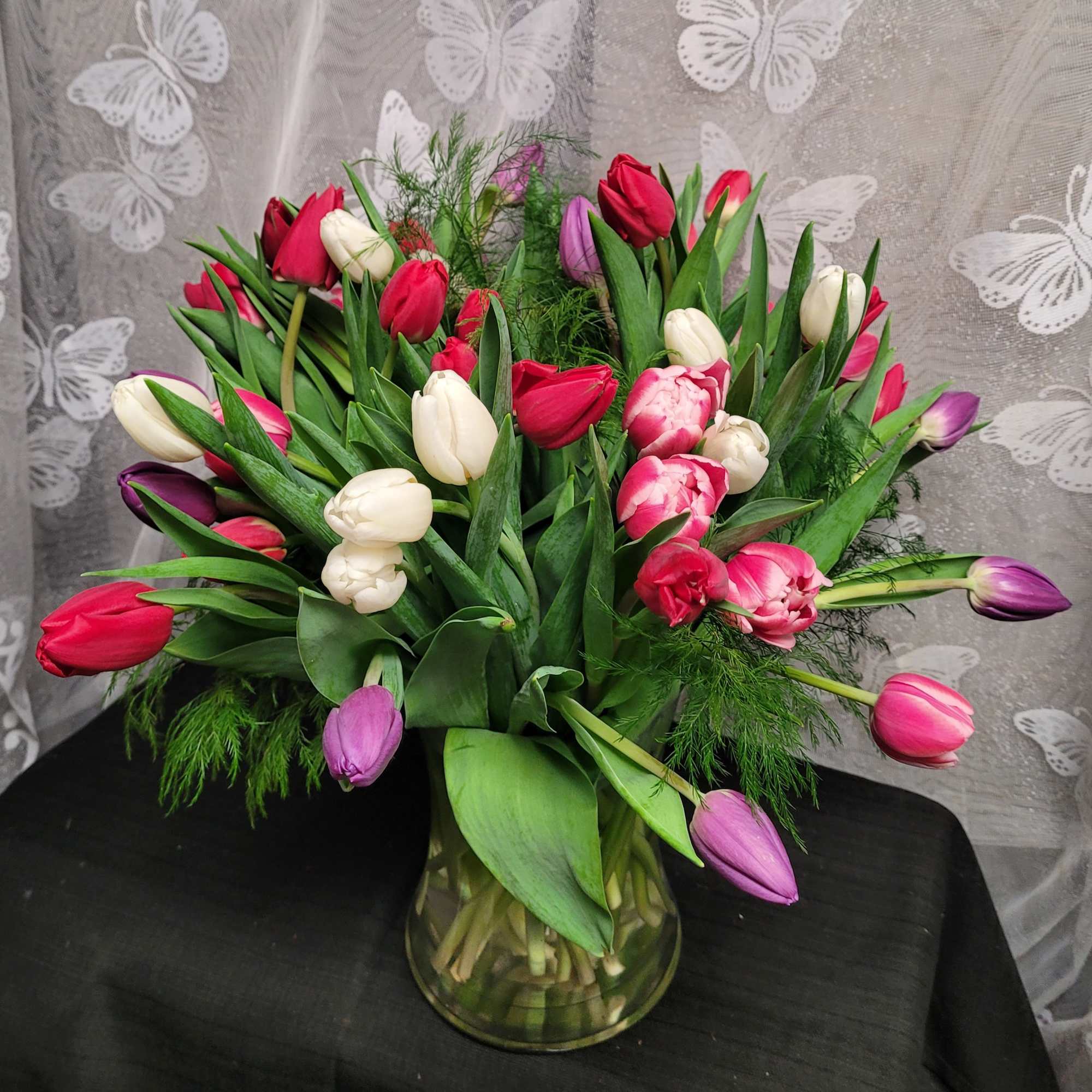 A lively bouquet of mixed-color tulips-rich purples, bright reds, soft pinks, sunny