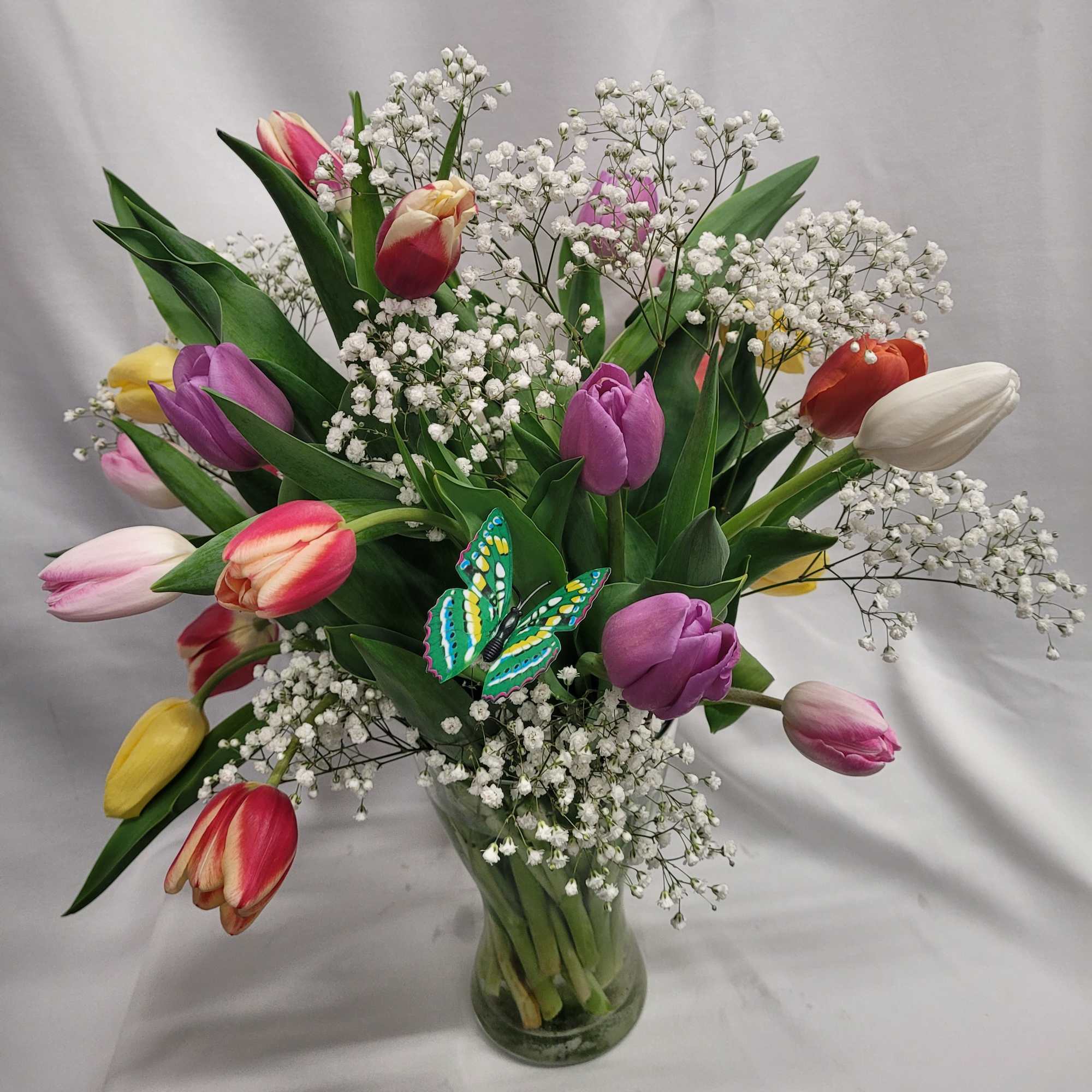 A lively bouquet of mixed-color tulips-rich purples, bright reds, soft pinks, sunny