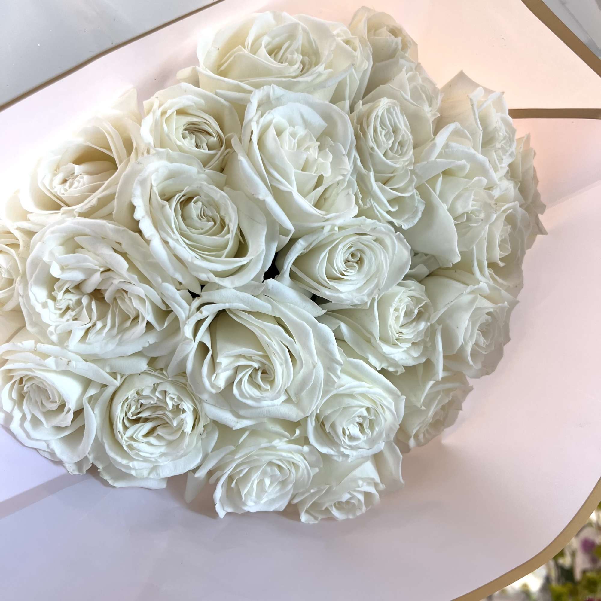 Bouquet of white roses wrapped in pale pink paper