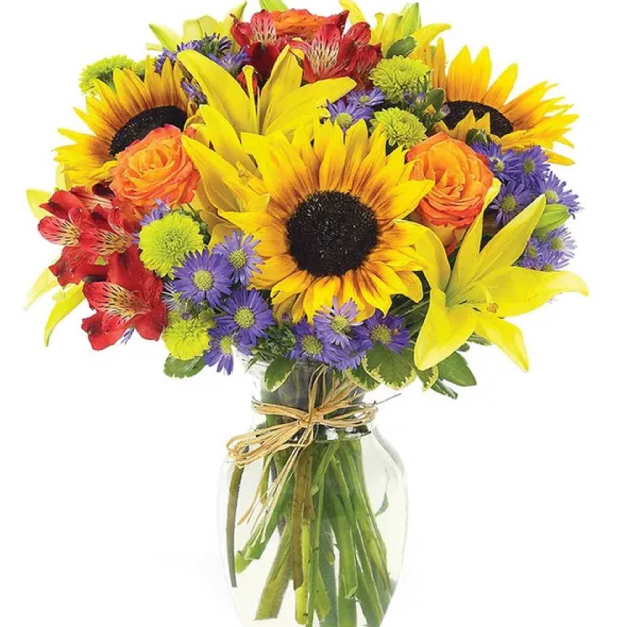 Bright mixed bouquet with sunflowers, lilies, roses, and purple daisies in a glass vase