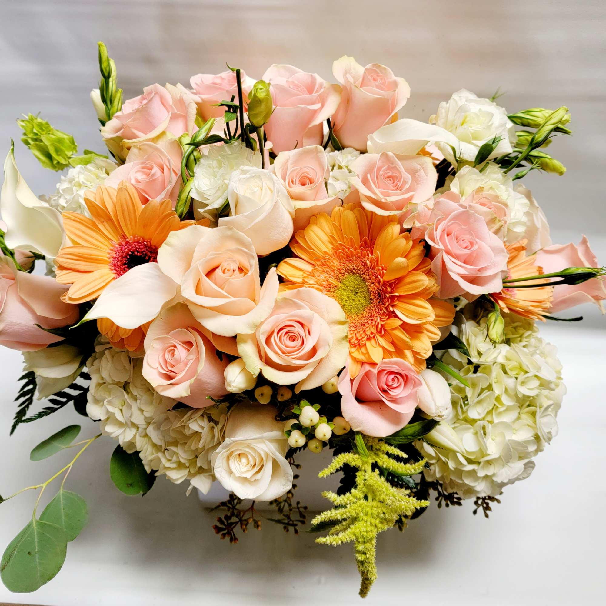 Bouquet of pink roses, orange gerbera daisies, and white hydrangeas