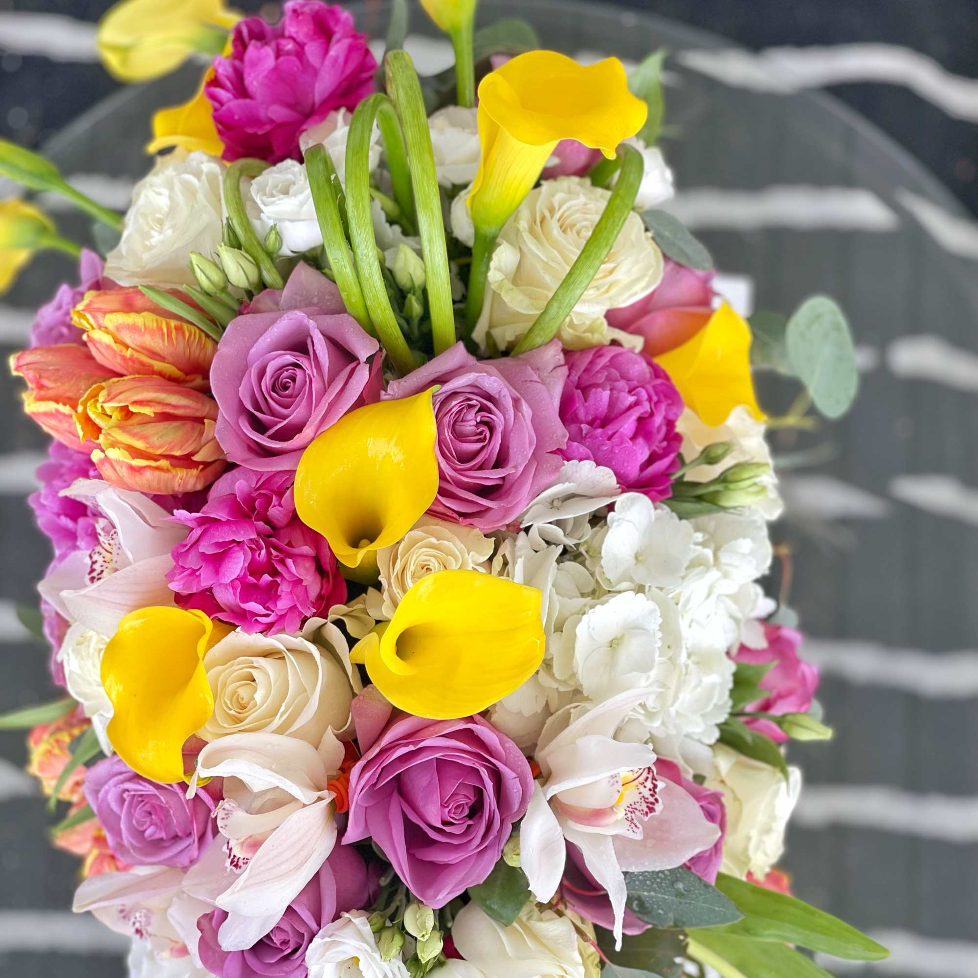 Bouquet of pink roses, yellow calla lilies, and white flowers