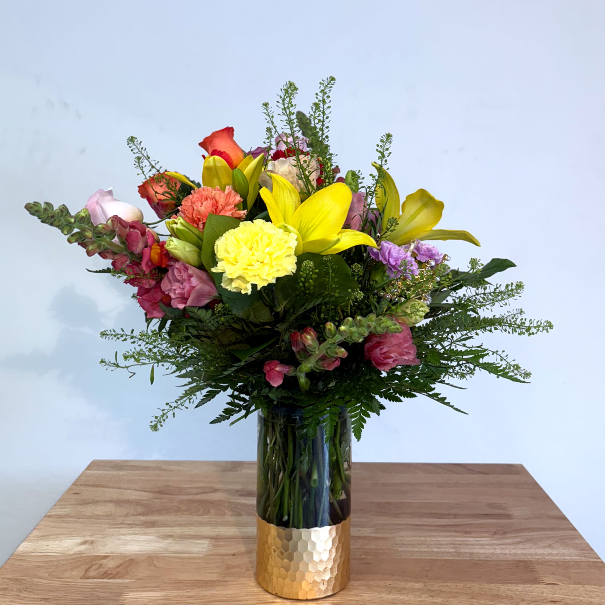 An elegant holiday arrangement showcasing a vibrant multicolored palette. Featuring flowers such